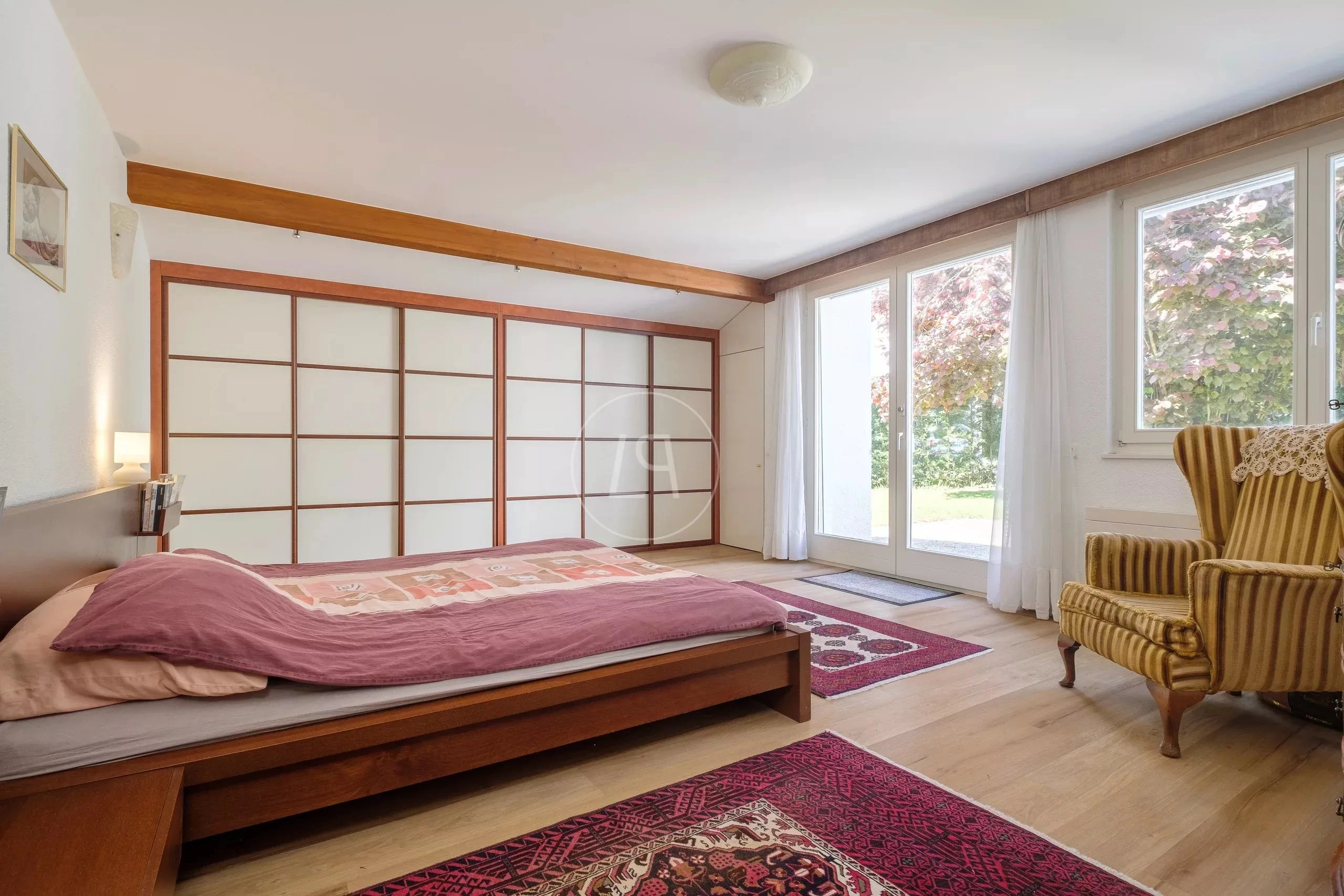 Helles Schlafzimmer mit großen Fenstern und Schiebetür