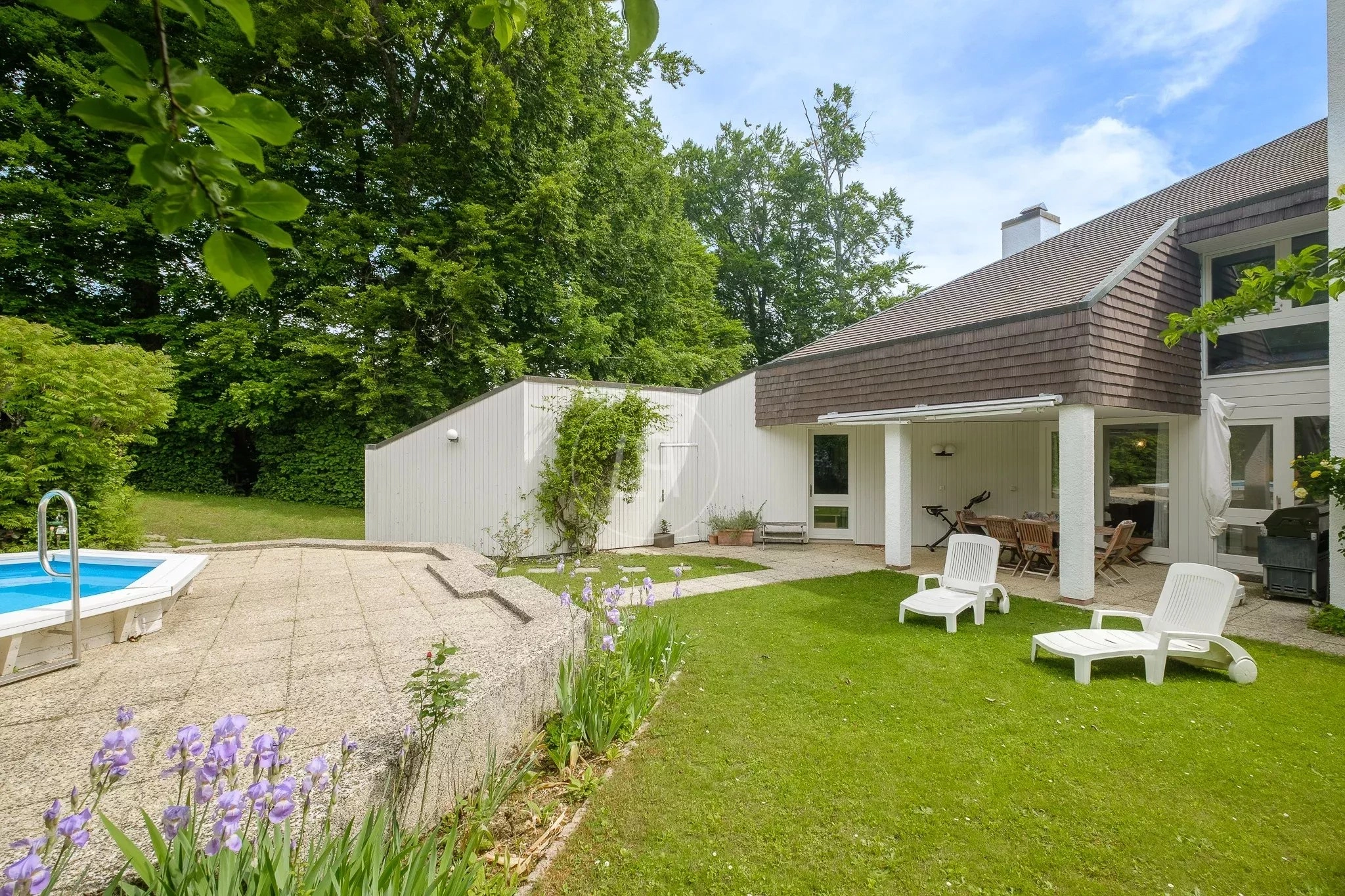 Außenansicht eines Gartens mit Terrasse und Pool