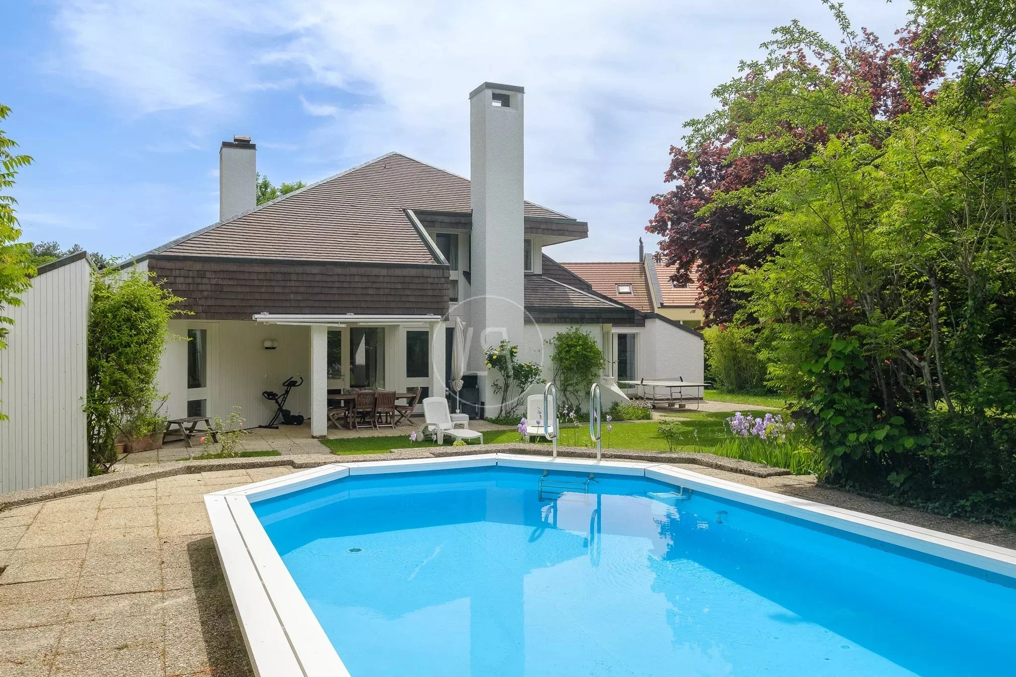 Außenansicht eines Hauses mit Pool und Garten