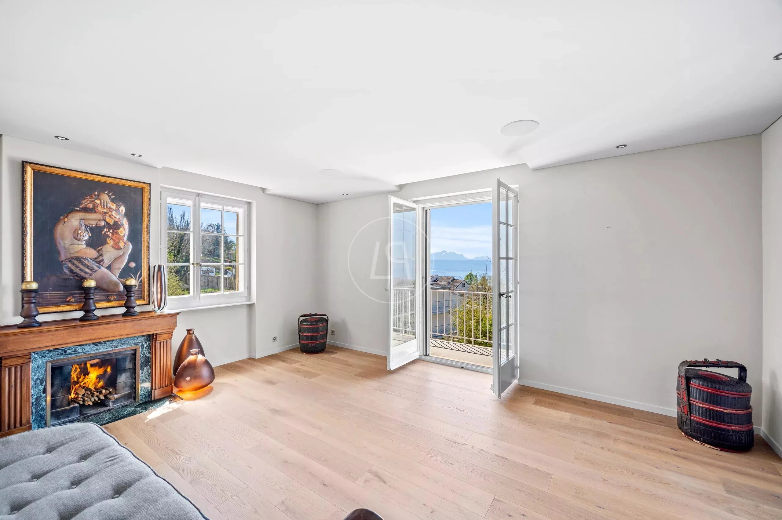 Helles Wohnzimmer mit Kamin und Balkonblick