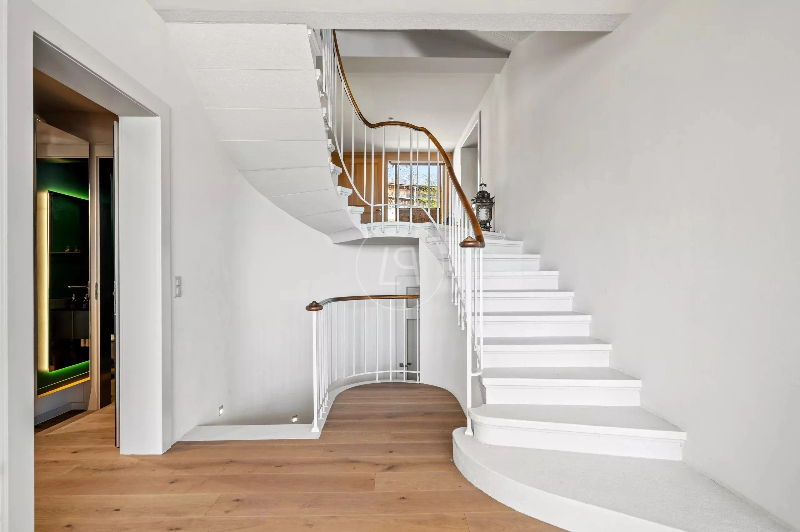 Geschwungene Treppe im hellen Flur