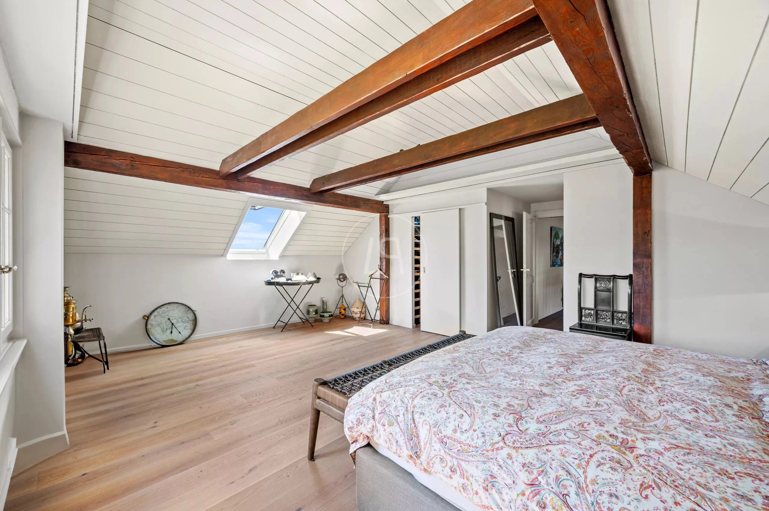 Dachgeschoss-Schlafzimmer mit sichtbaren Holzbalken