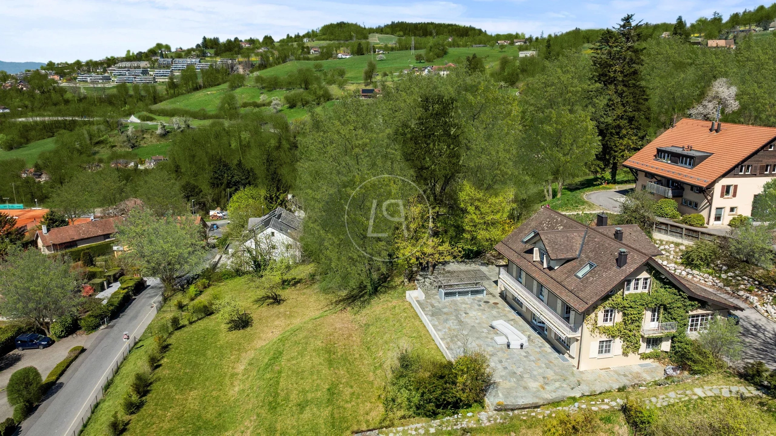 Luftaufnahme eines Hauses in grüner Hanglage