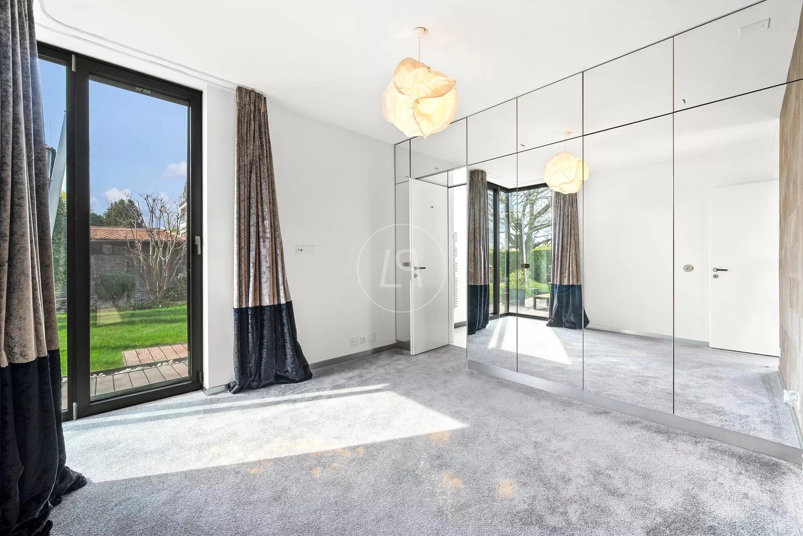 Helles, modernes Schlafzimmer mit Spiegelwand und Gartenblick