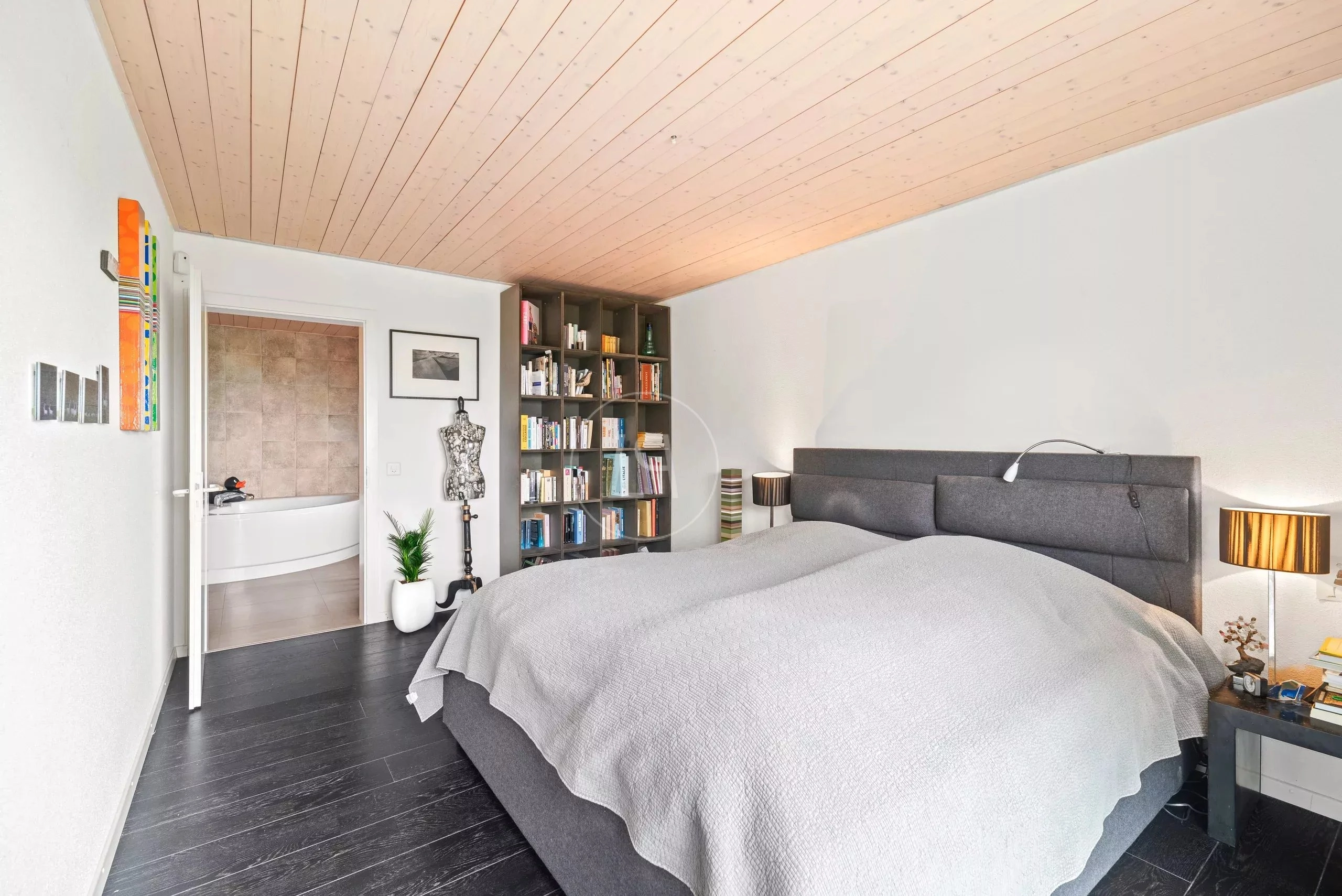 Modernes Schlafzimmer mit dunklem Boden und Holzdecke