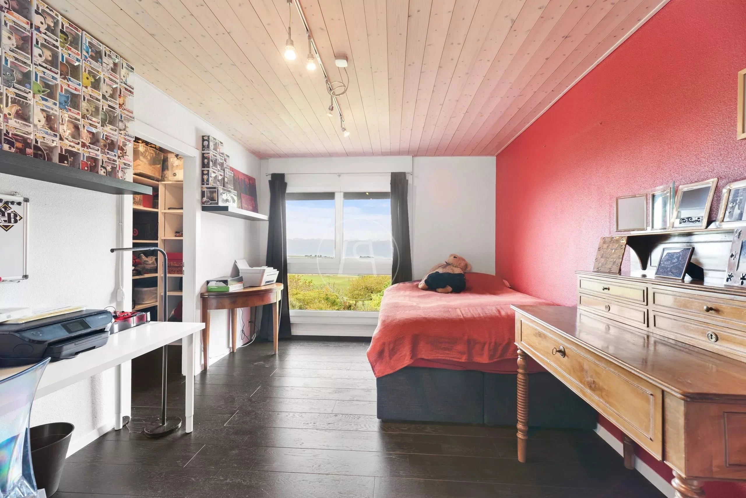 Gemütliches Schlafzimmer mit dunklem Boden und Fensterblick