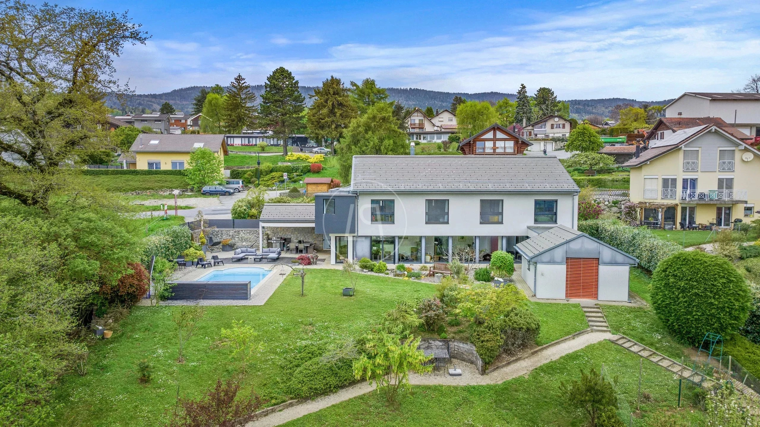 Luftaufnahme eines Einfamilienhauses mit großem Garten und Pool