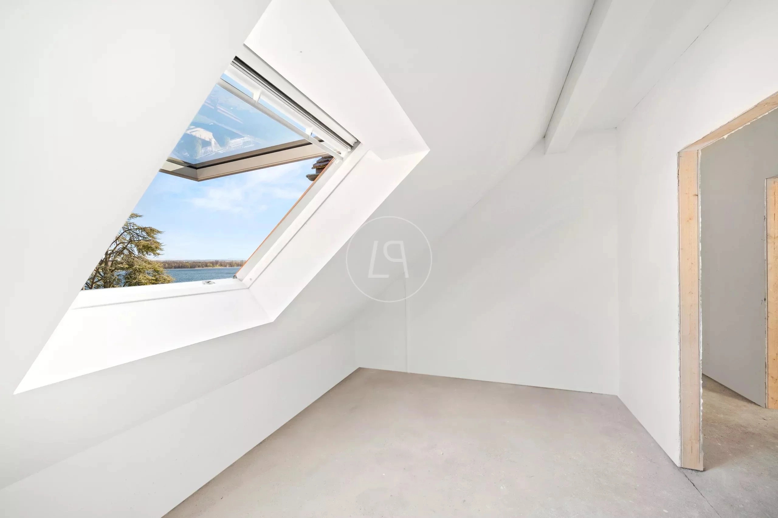 Ausgebauter Dachraum mit Dachfenster und Seeblick