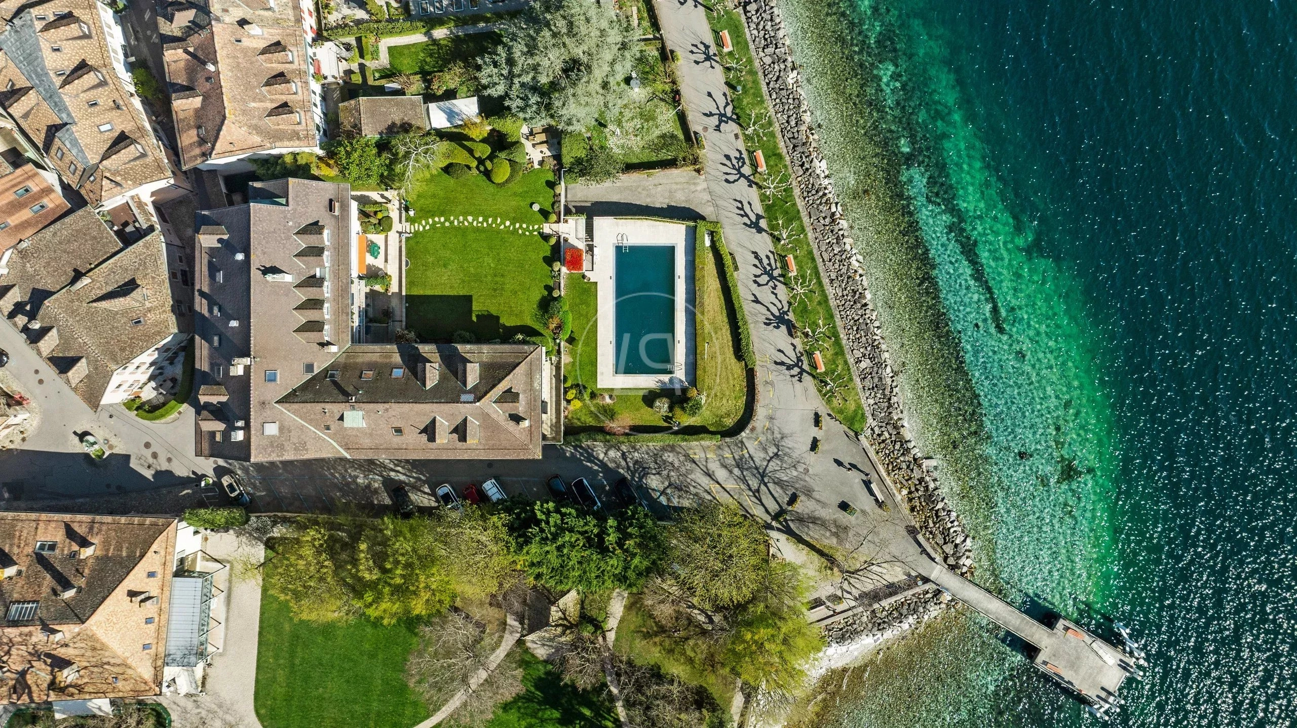 Luftaufnahme einer Uferimmobilie mit Pool und Garten