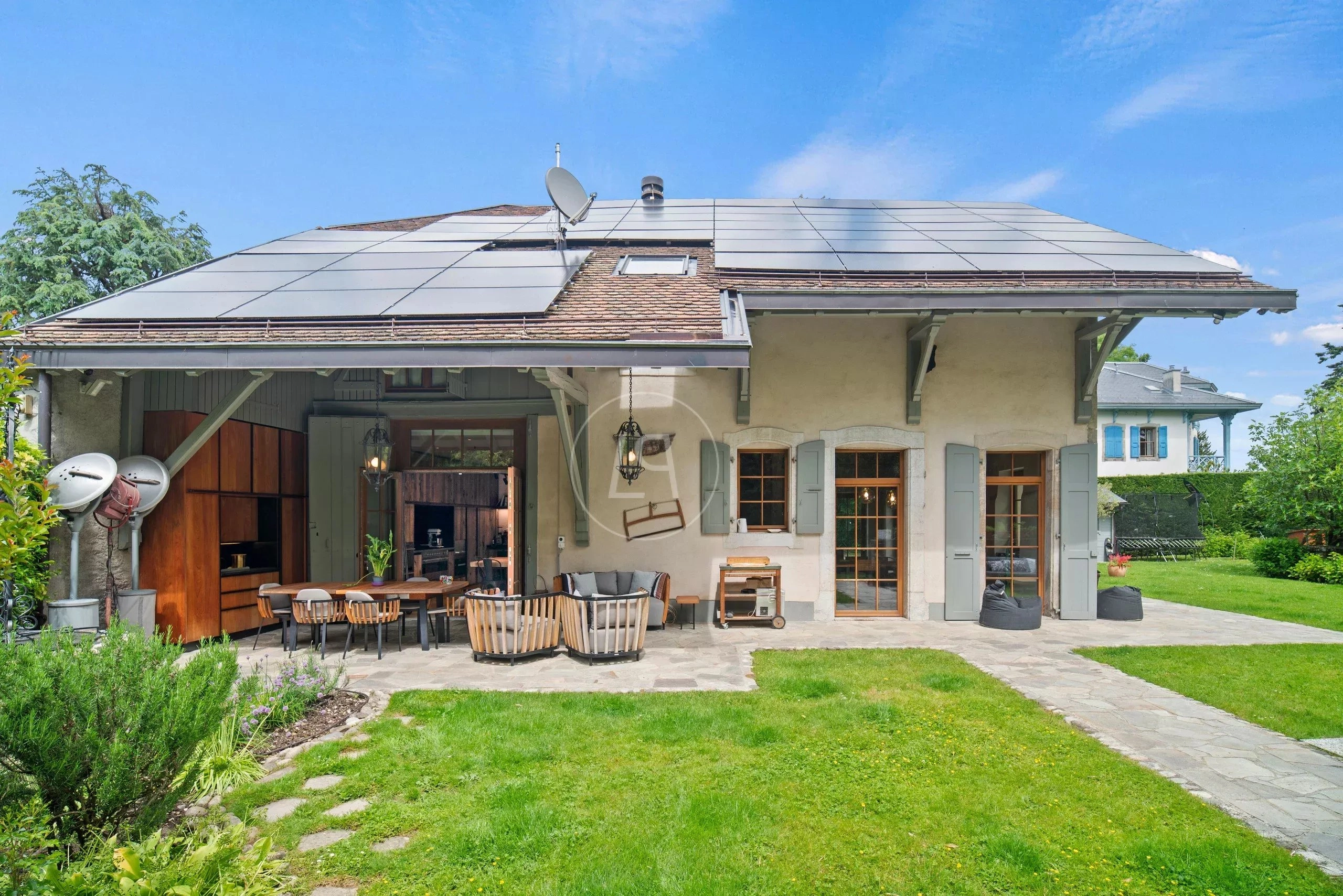 Außenansicht eines Hauses mit großer Terrasse und Solardach