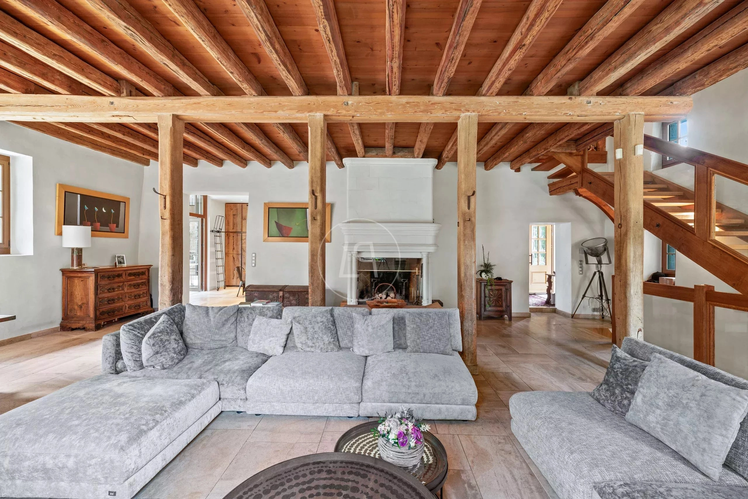 Wohnzimmer mit offenem Kamin und sichtbaren Holzbalken