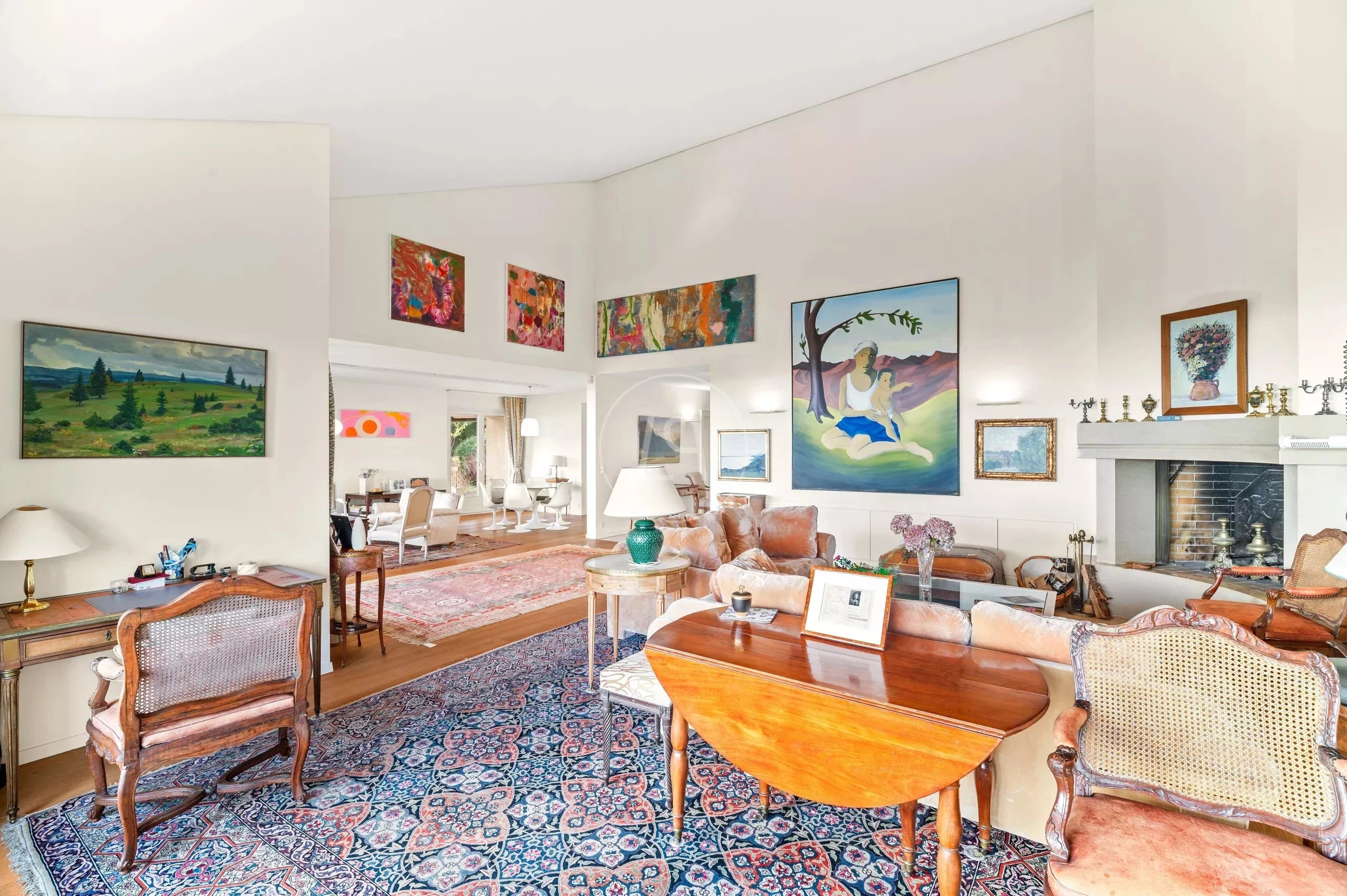 Großzügiges Wohnzimmer mit Kunstwerken und Kamin