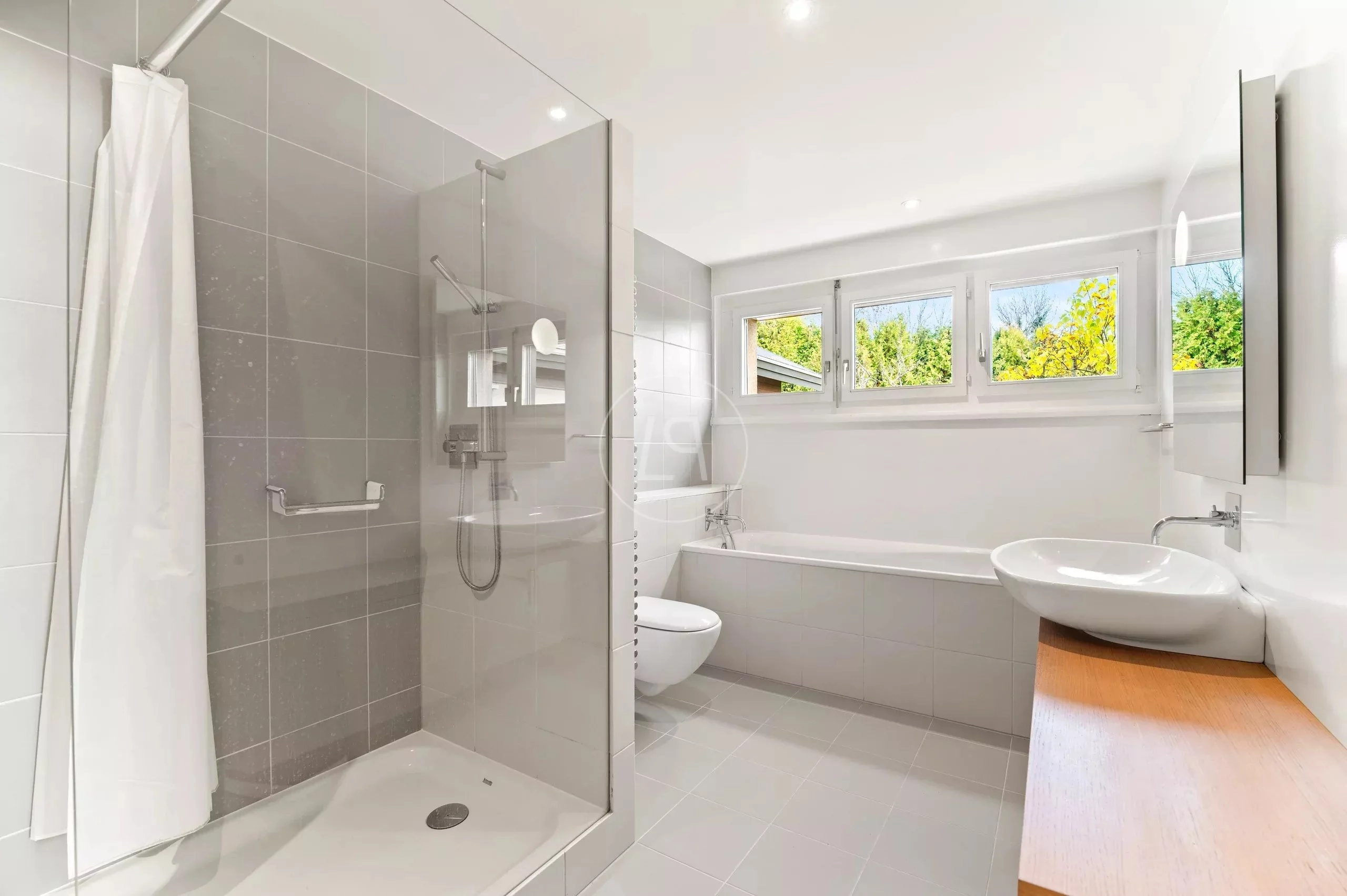Modernes Badezimmer mit Dusche, Wanne und Fensterfront