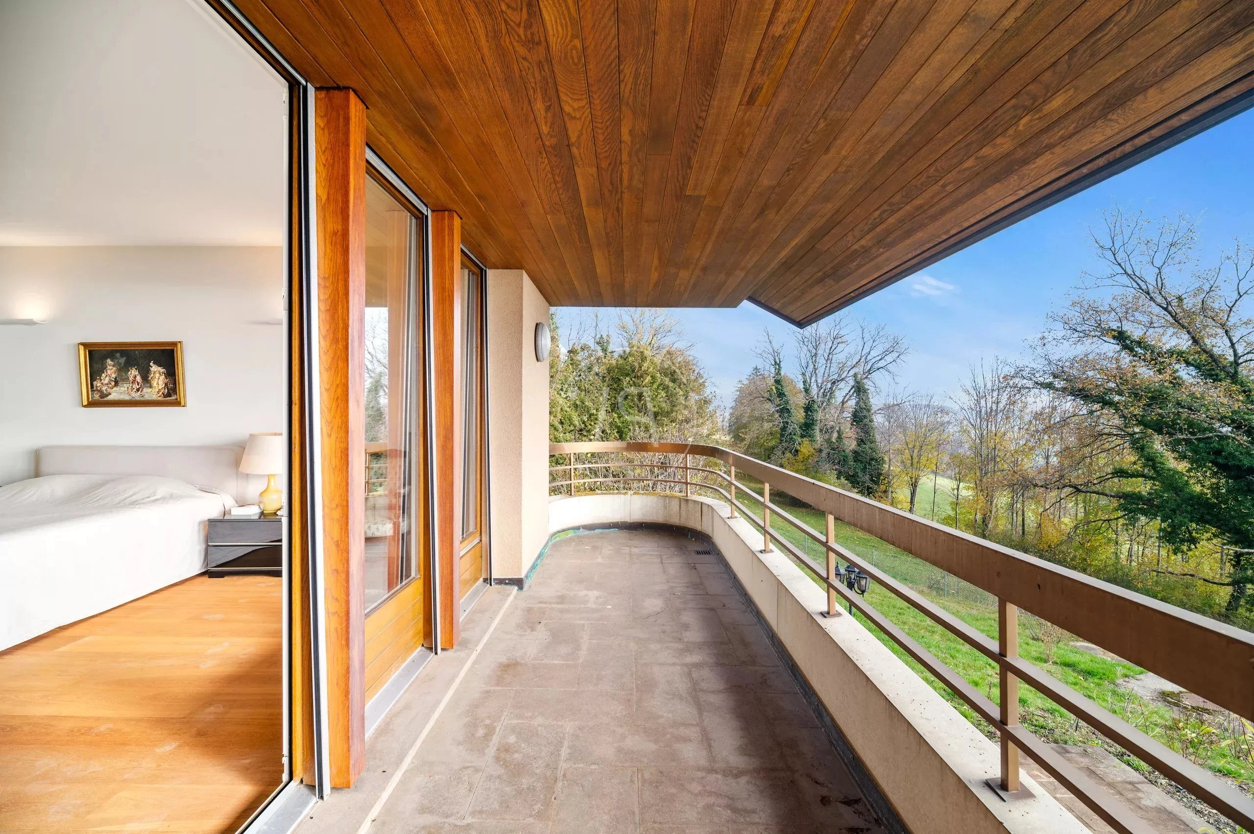 Balkon mit Blick ins Grüne und angrenzendem Schlafzimmer