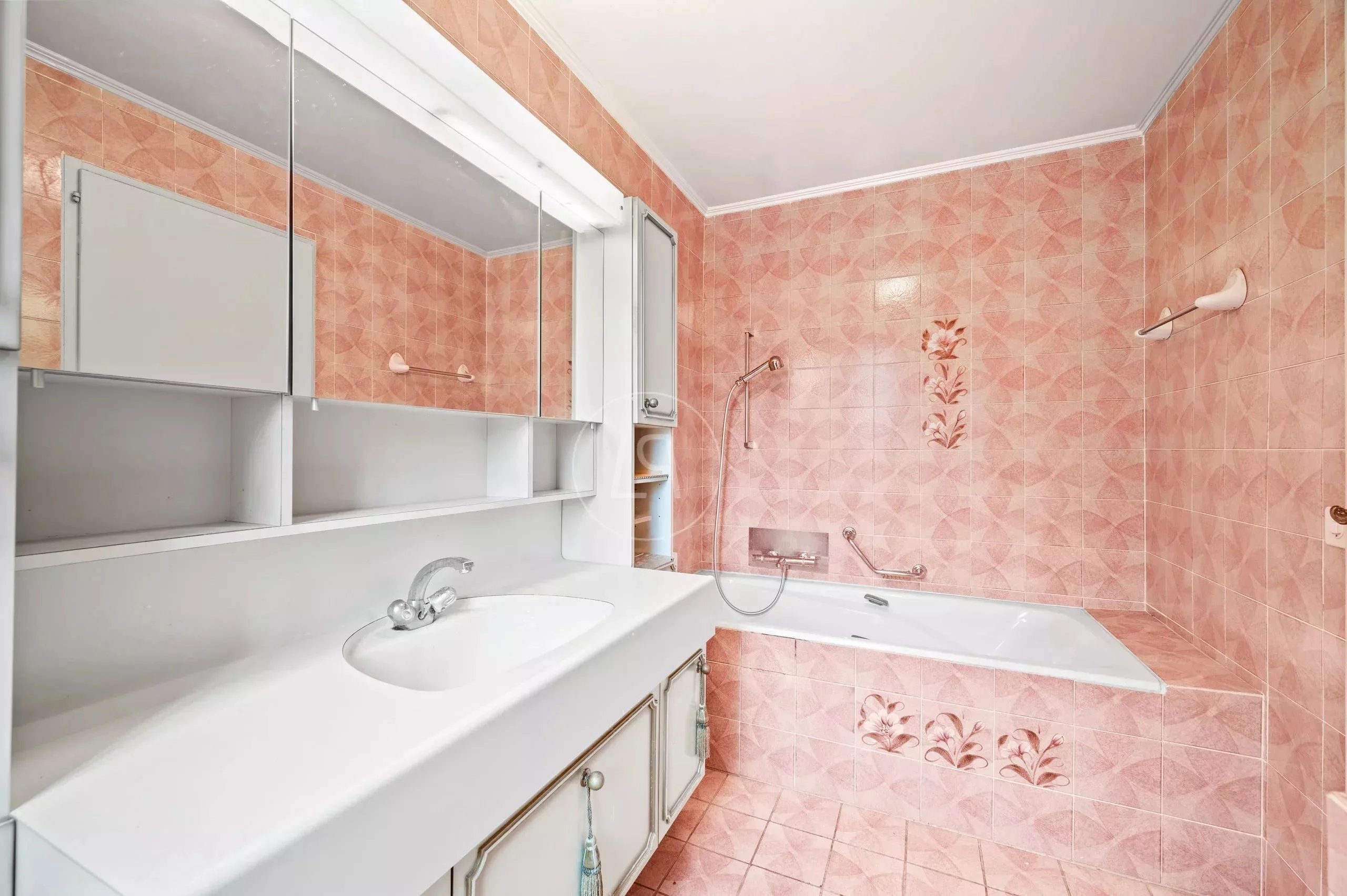 Badezimmer mit rosa Fliesen und Badewanne