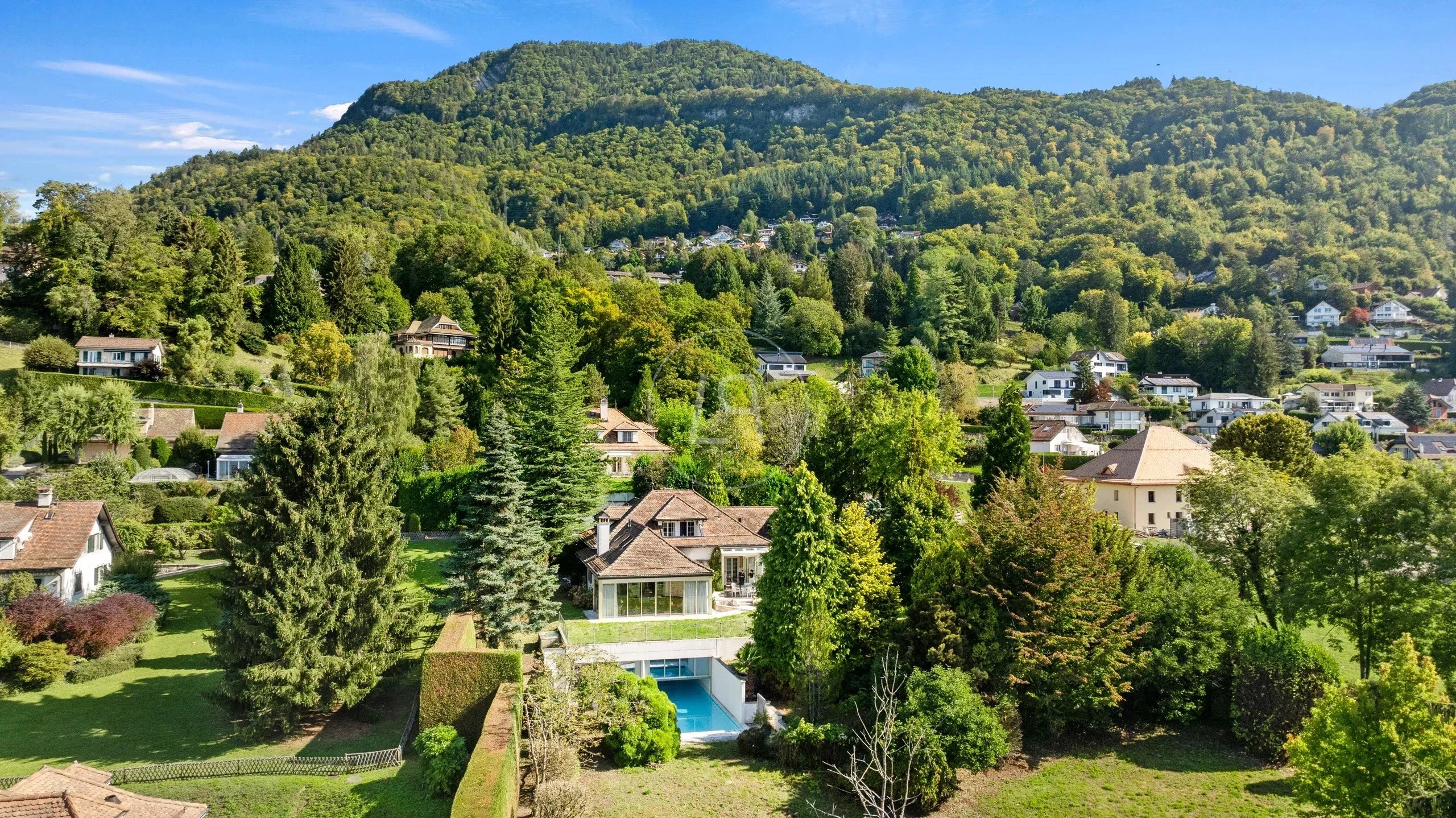 Weitblick auf bewaldeten Hang mit Wohnsiedlung