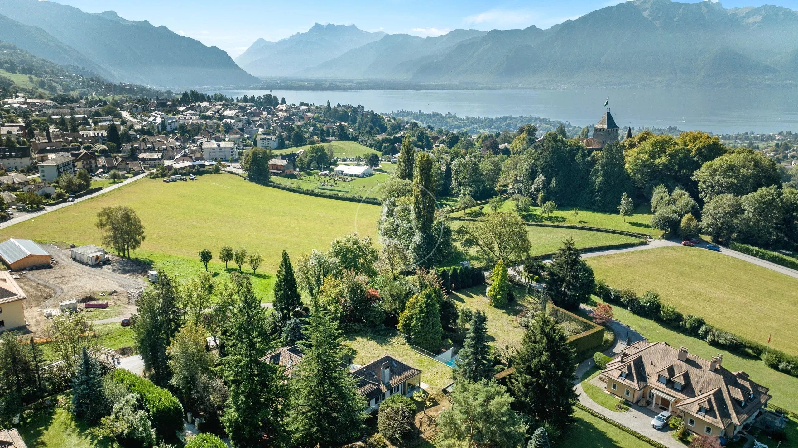 Luftaufnahme eines Sees mit Bergkulisse und Ortschaft