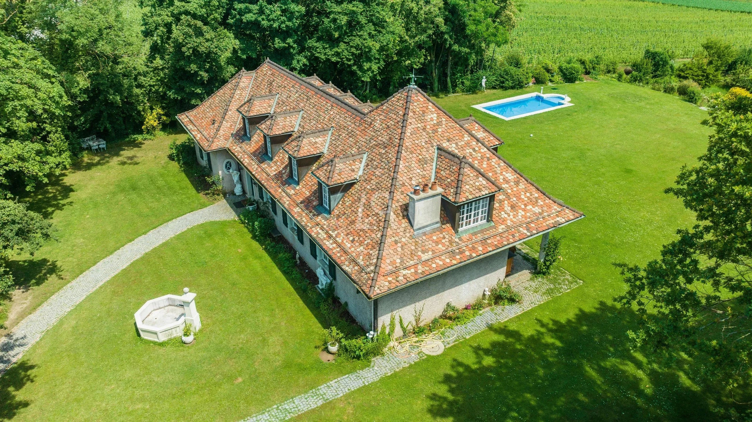 Luftaufnahme eines Landhauses mit großem Garten und Pool