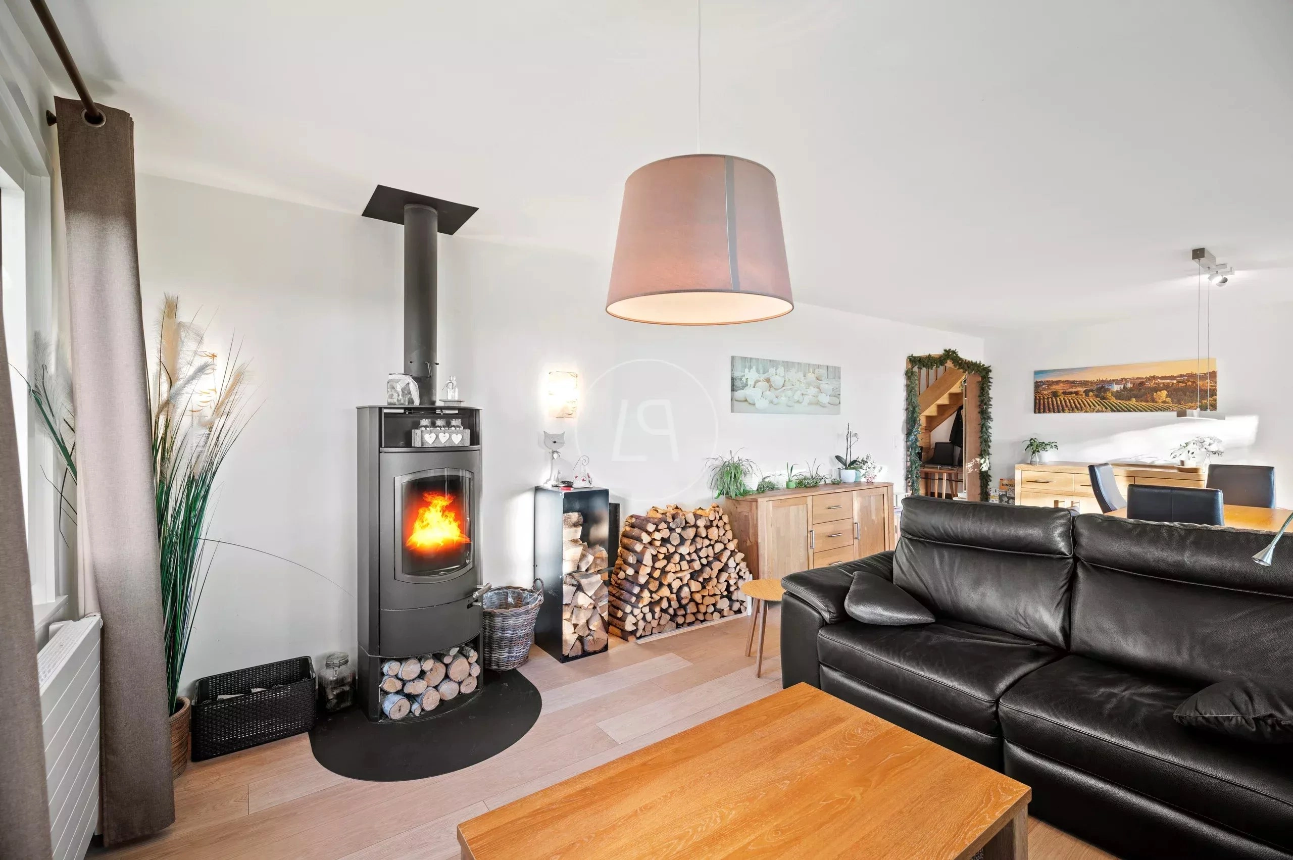 Gemütliches Wohnzimmer mit Kamin und schwarzem Sofa