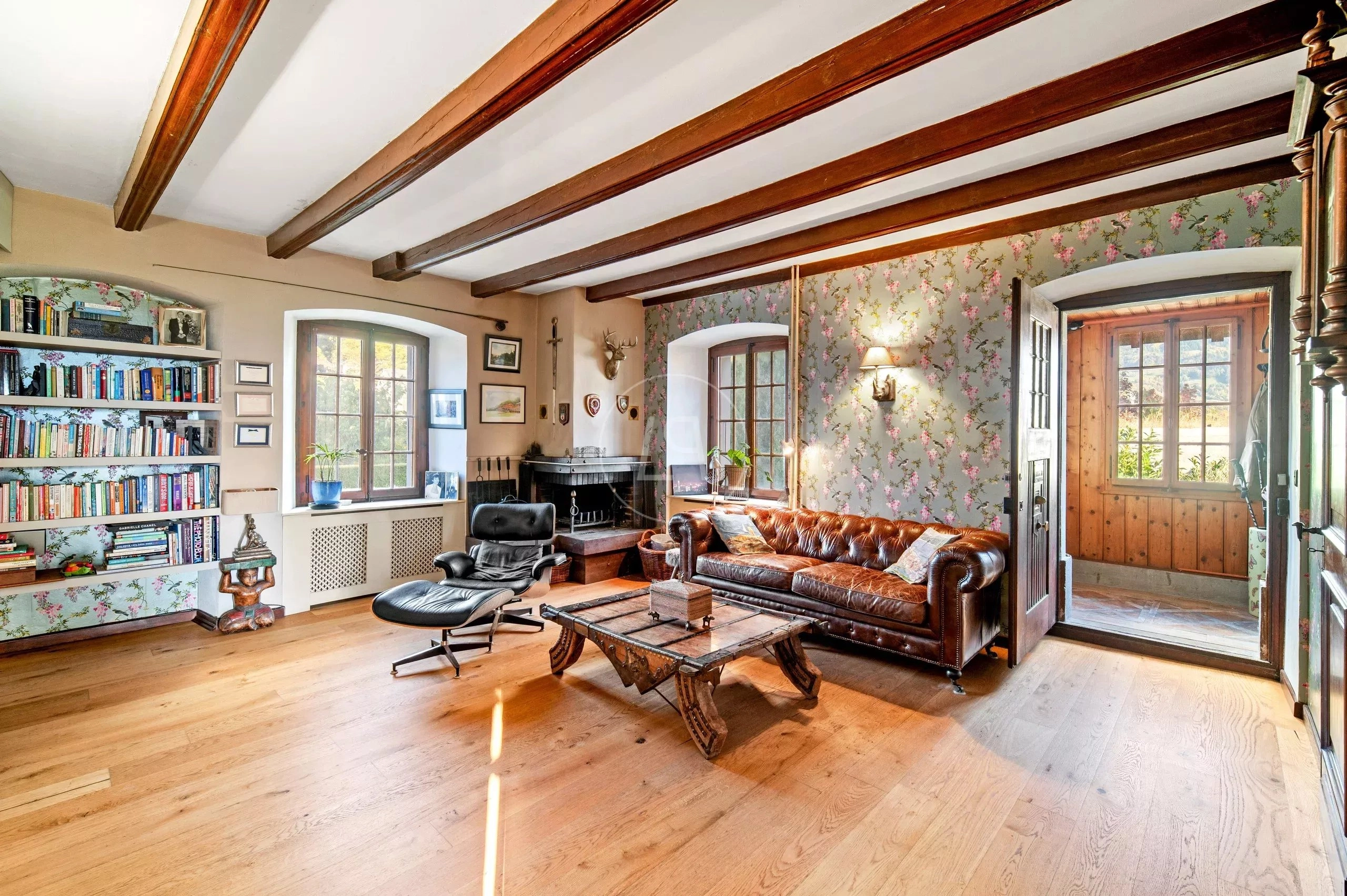 Gemütliches Wohnzimmer mit Kamin und floraler Tapete