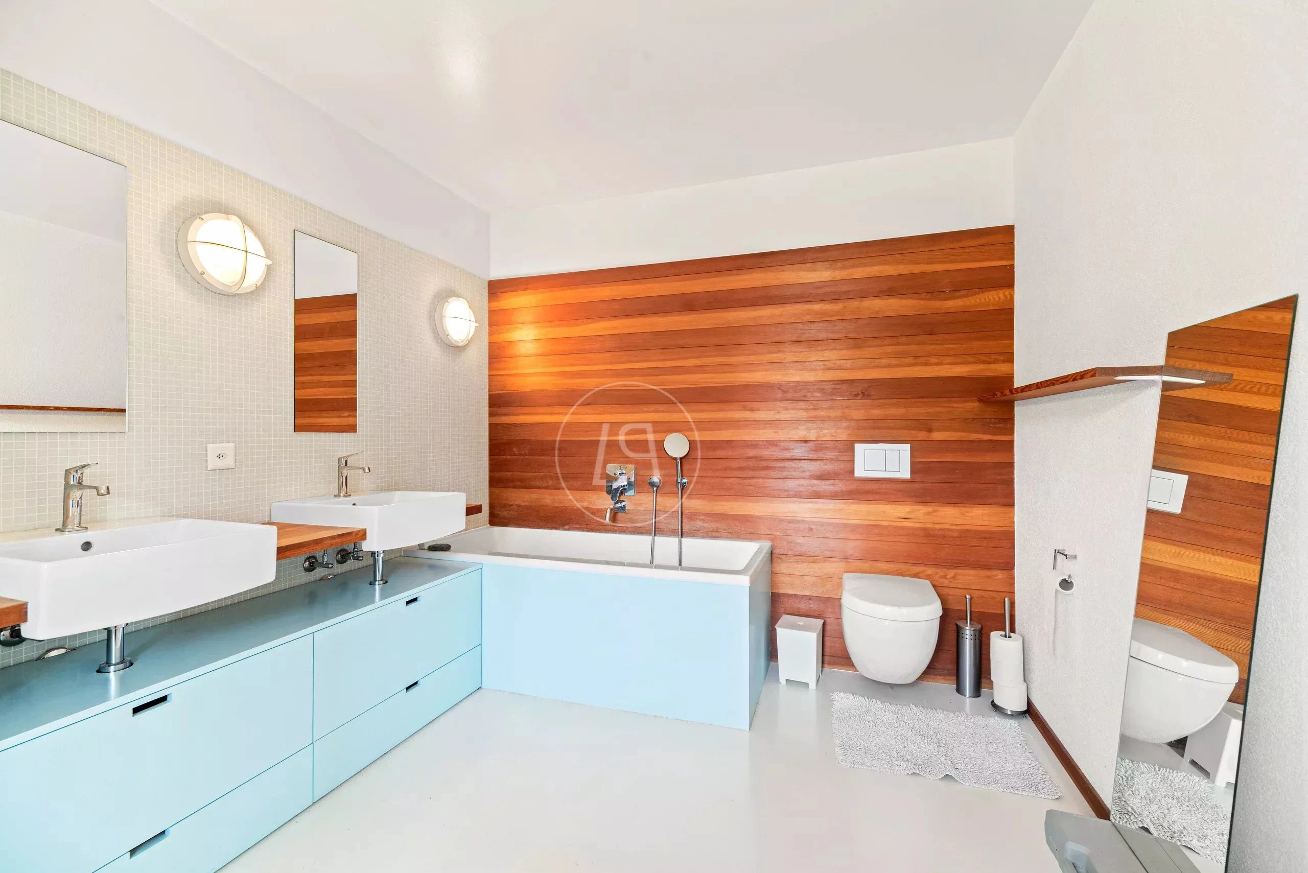 Modernes Badezimmer mit Holzakzentwand und Doppelwaschbecken