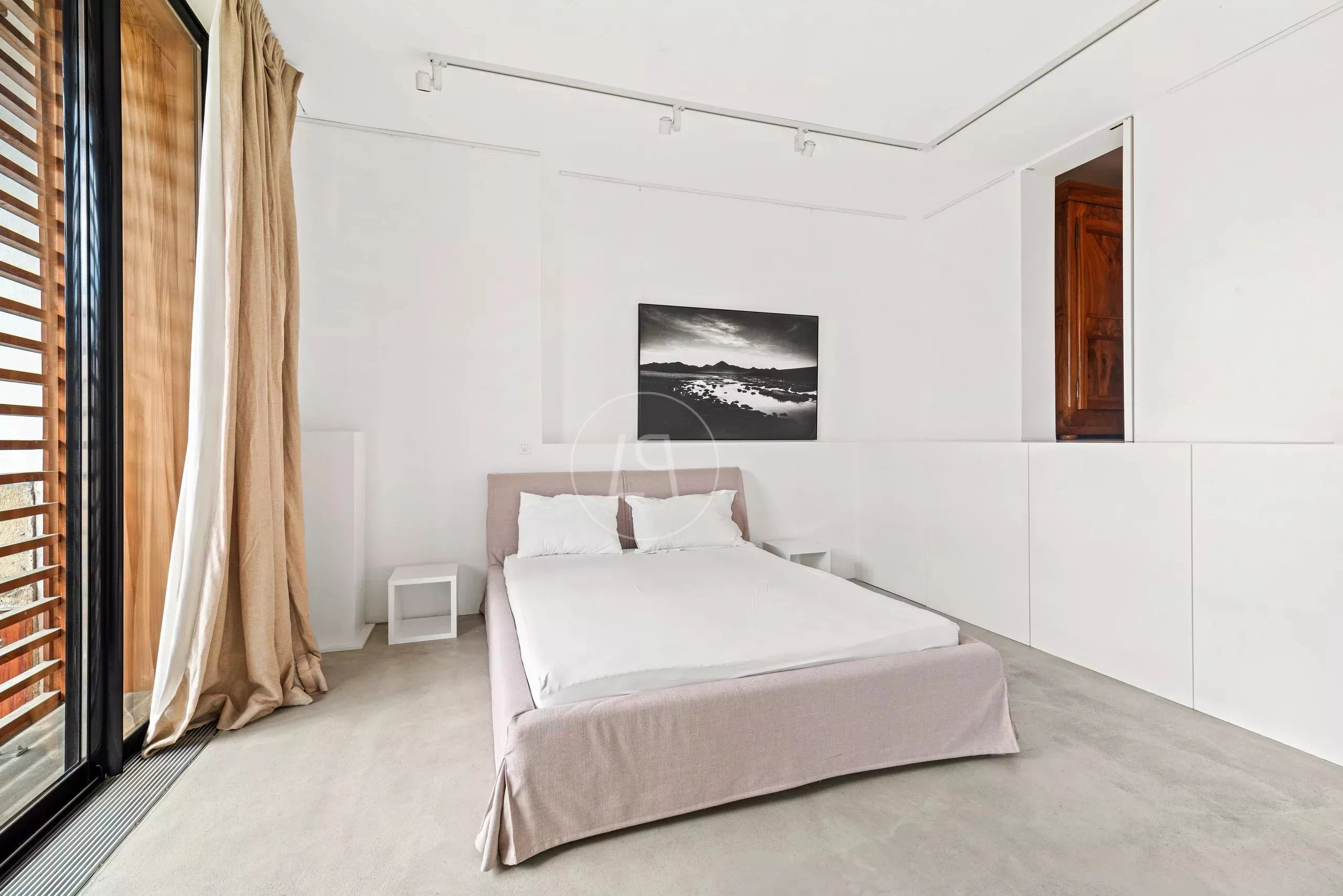Minimalistisch eingerichtetes Schlafzimmer mit großer Fensterfront