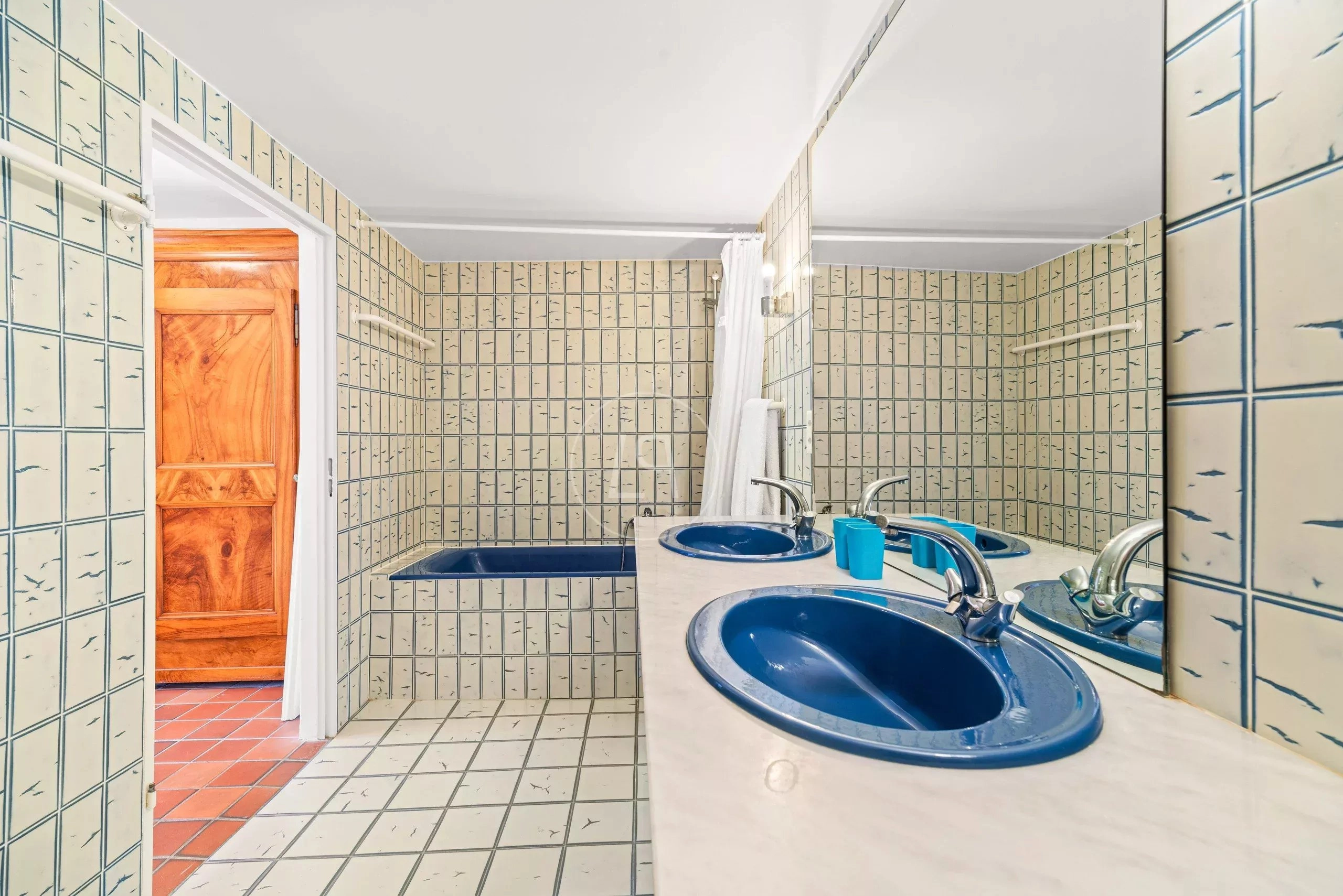 Badezimmer mit Doppelwaschbecken und Fliesenspiegel
