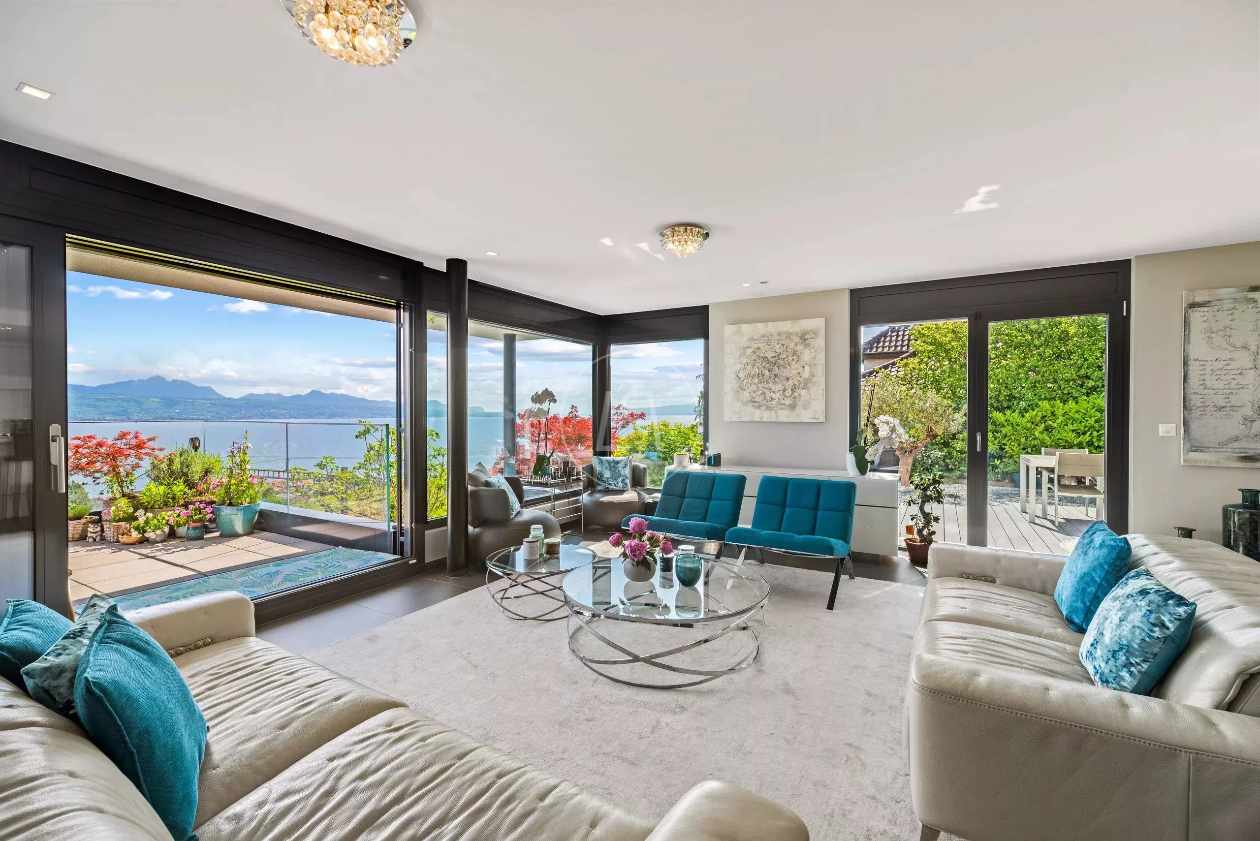 Helles Wohnzimmer mit Panoramablick auf Wasser und Berge