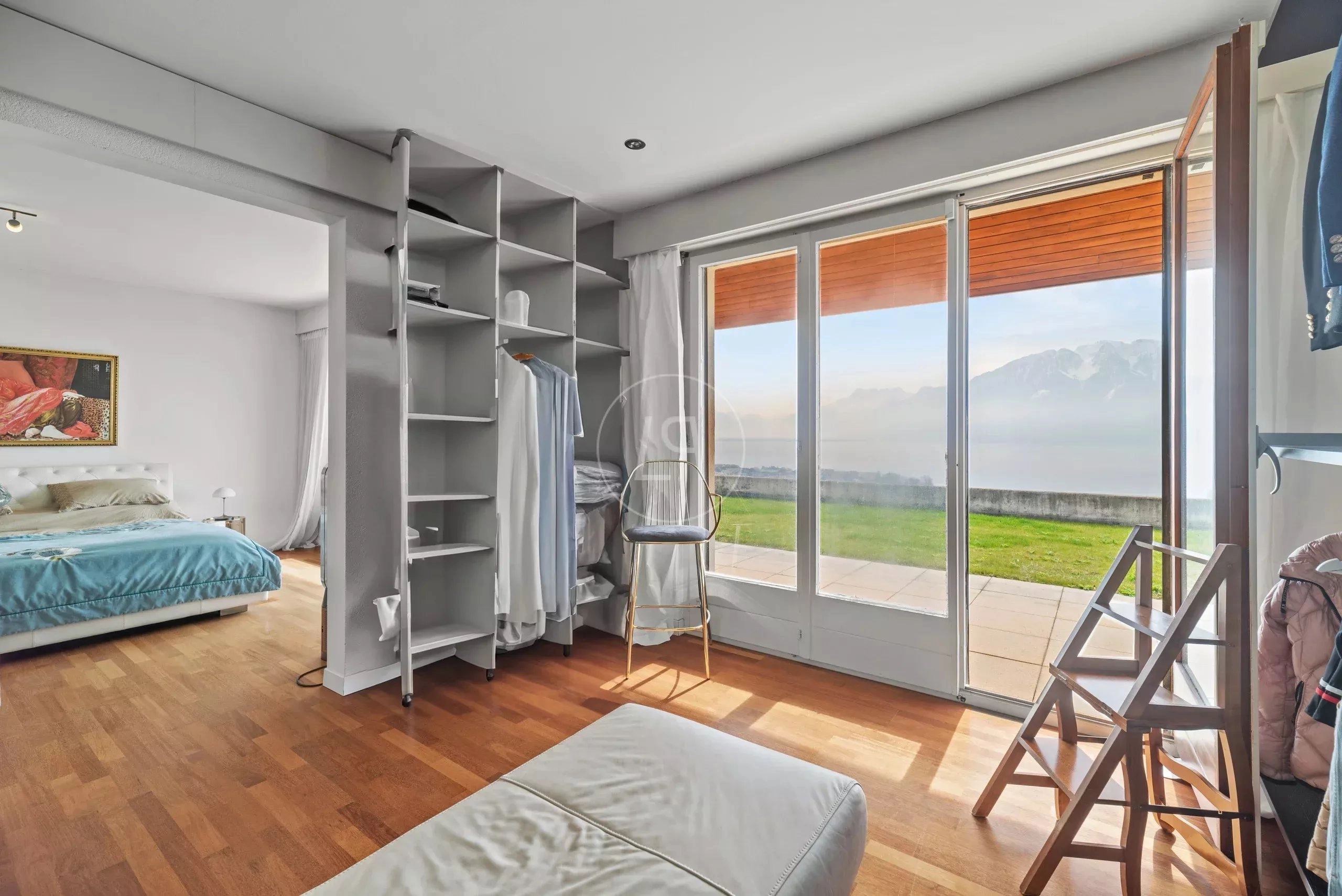 Helles Schlafzimmer mit Balkon- und Seeblick