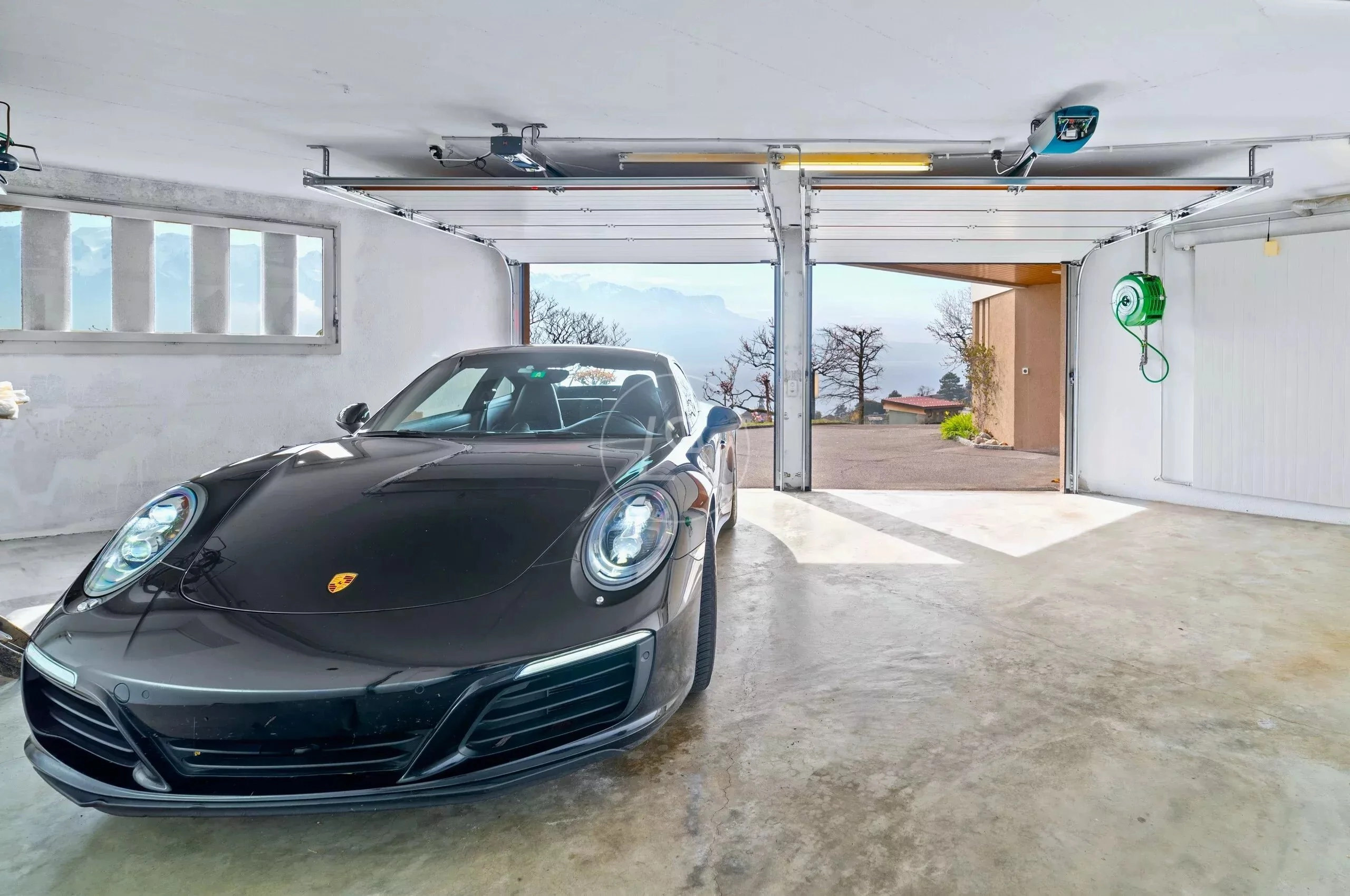 Garage mit Sportwagen und Talblick
