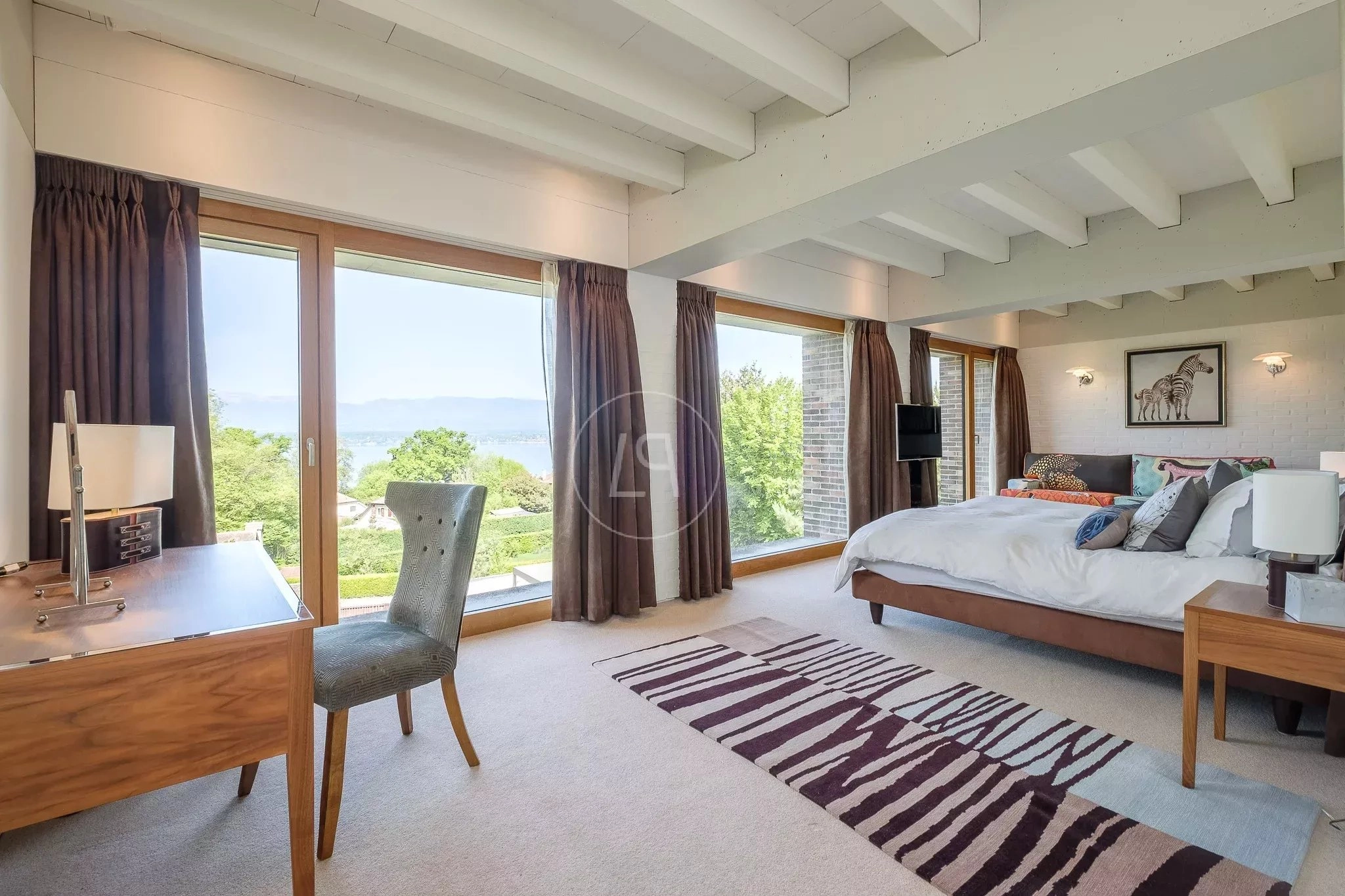 Helles Schlafzimmer mit großflächiger Verglasung und Bergblick
