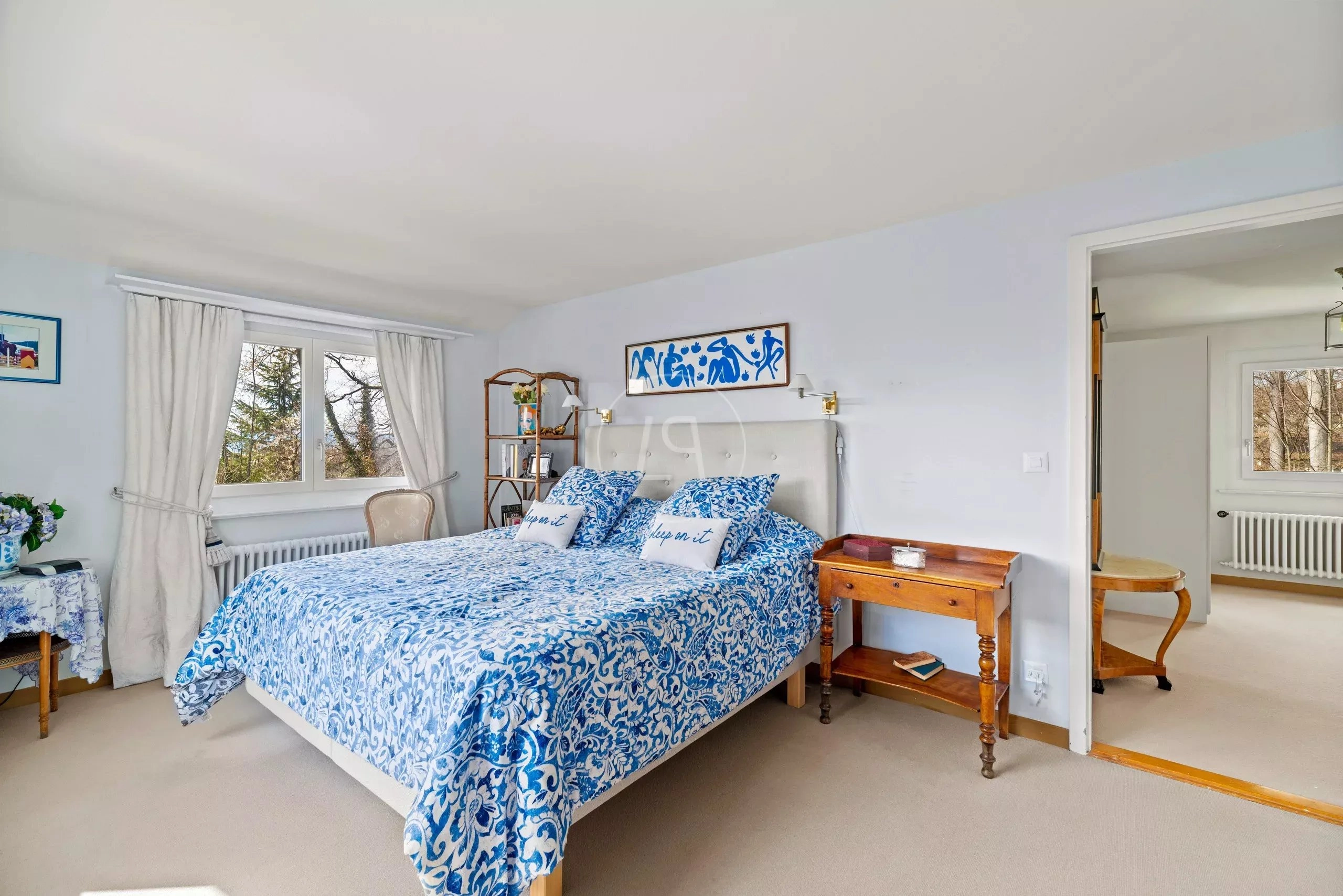 Helles Schlafzimmer mit blau-weißem Betttextil