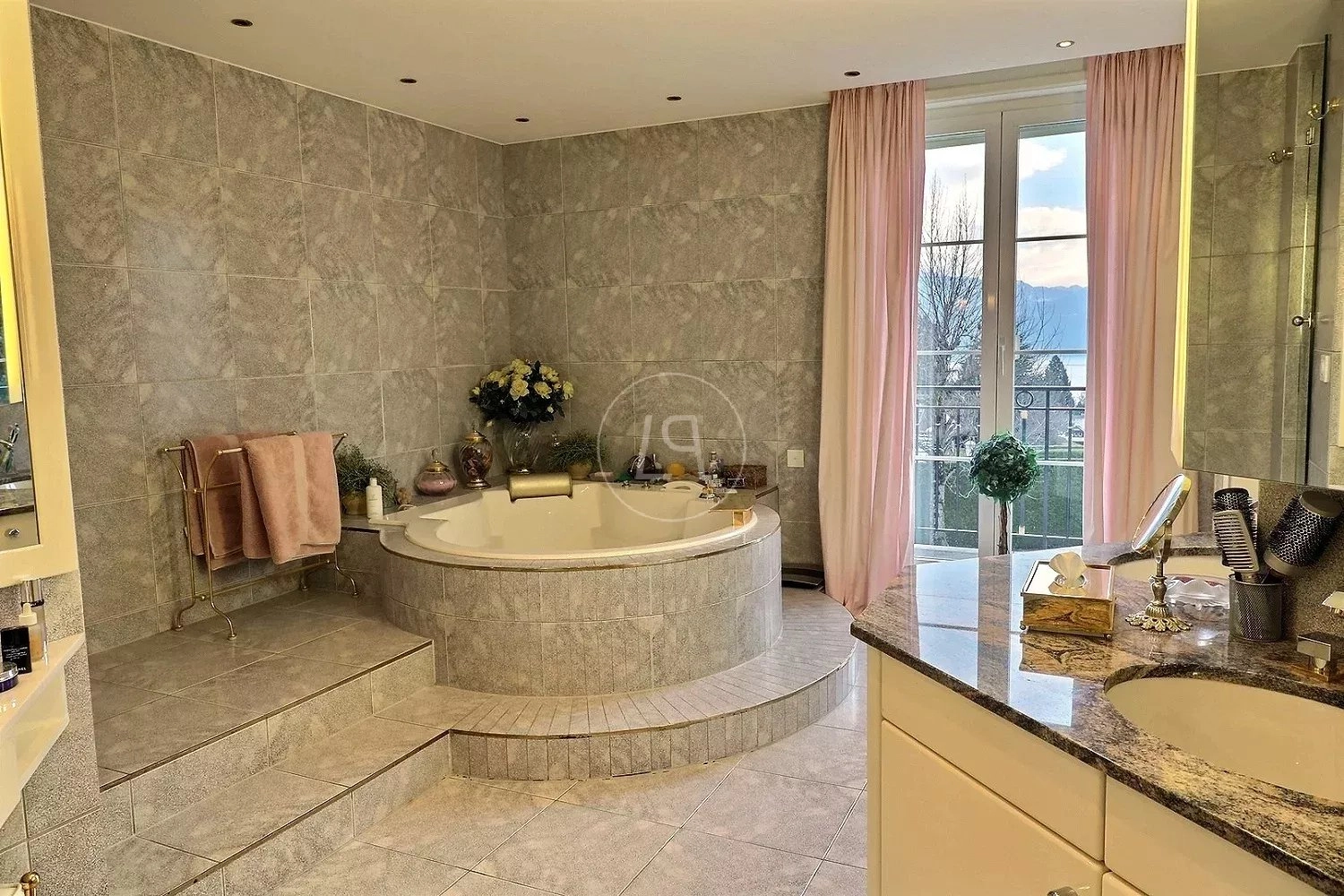 Luxuriöses Badezimmer mit Rundwanne und Balkonblick