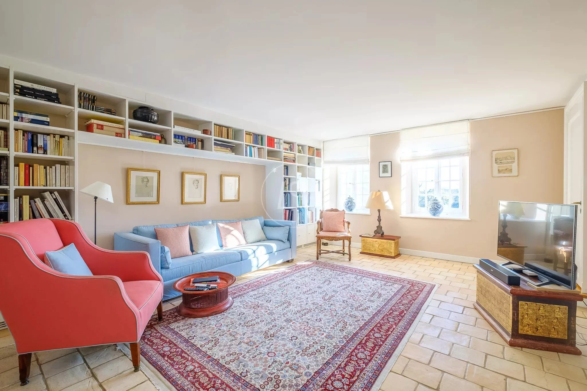Helles, klassisch eingerichtetes Wohnzimmer mit Bücherregalen