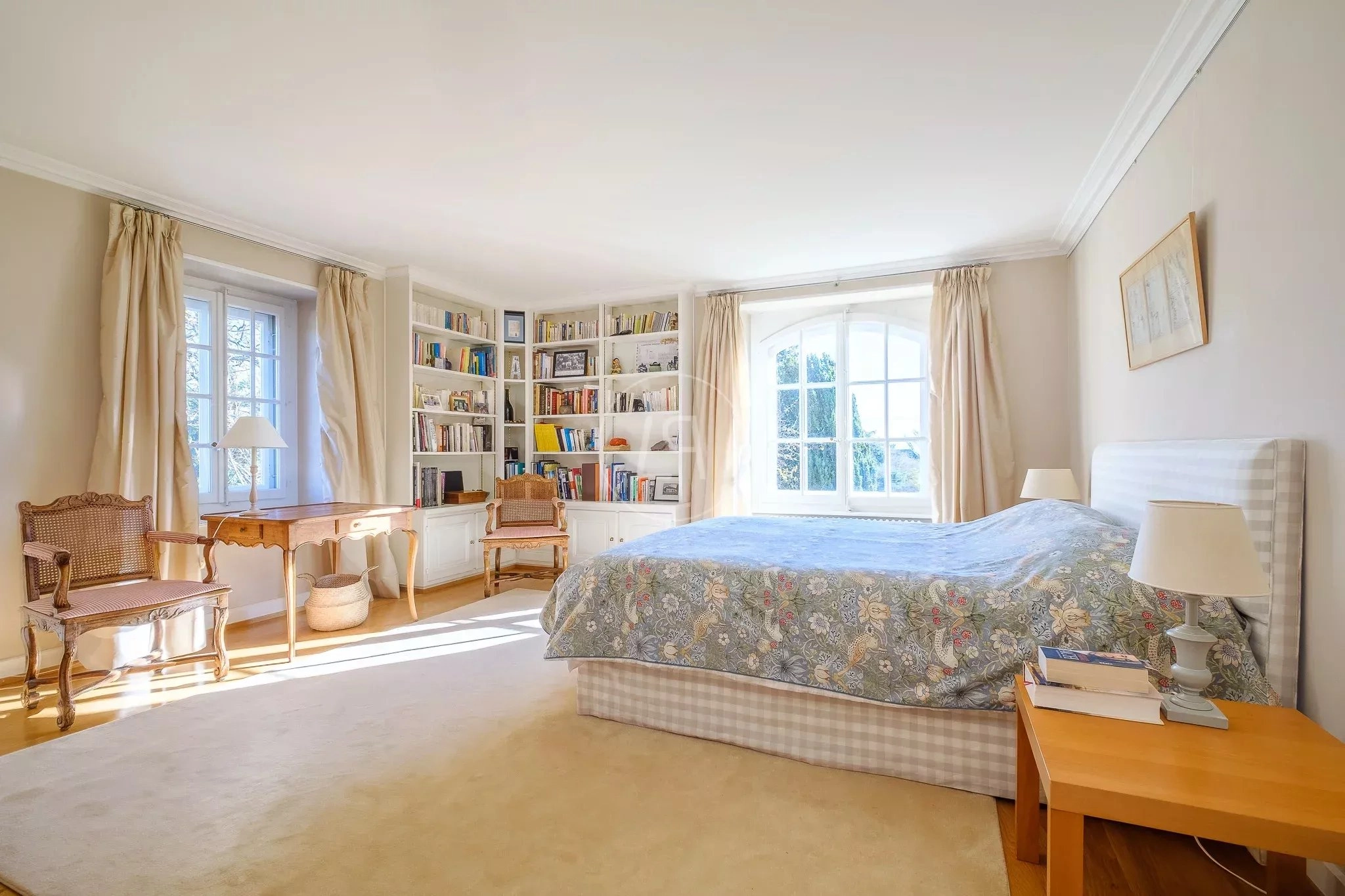 Helles Schlafzimmer mit Bücherregal und Sitzbereich