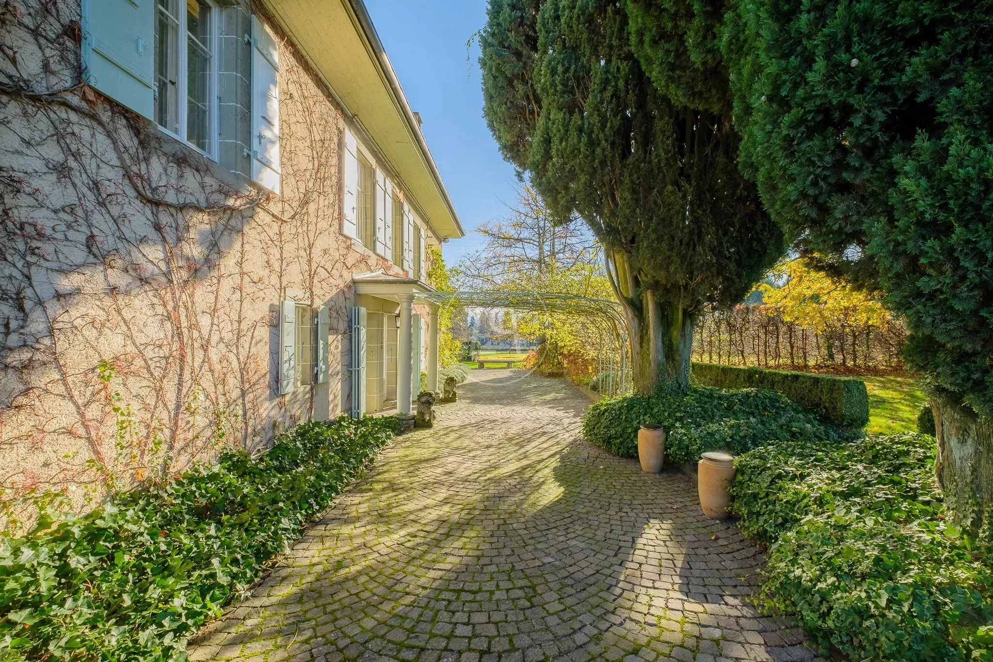 Außenansicht eines Landhauses mit bepflasterter Zufahrt