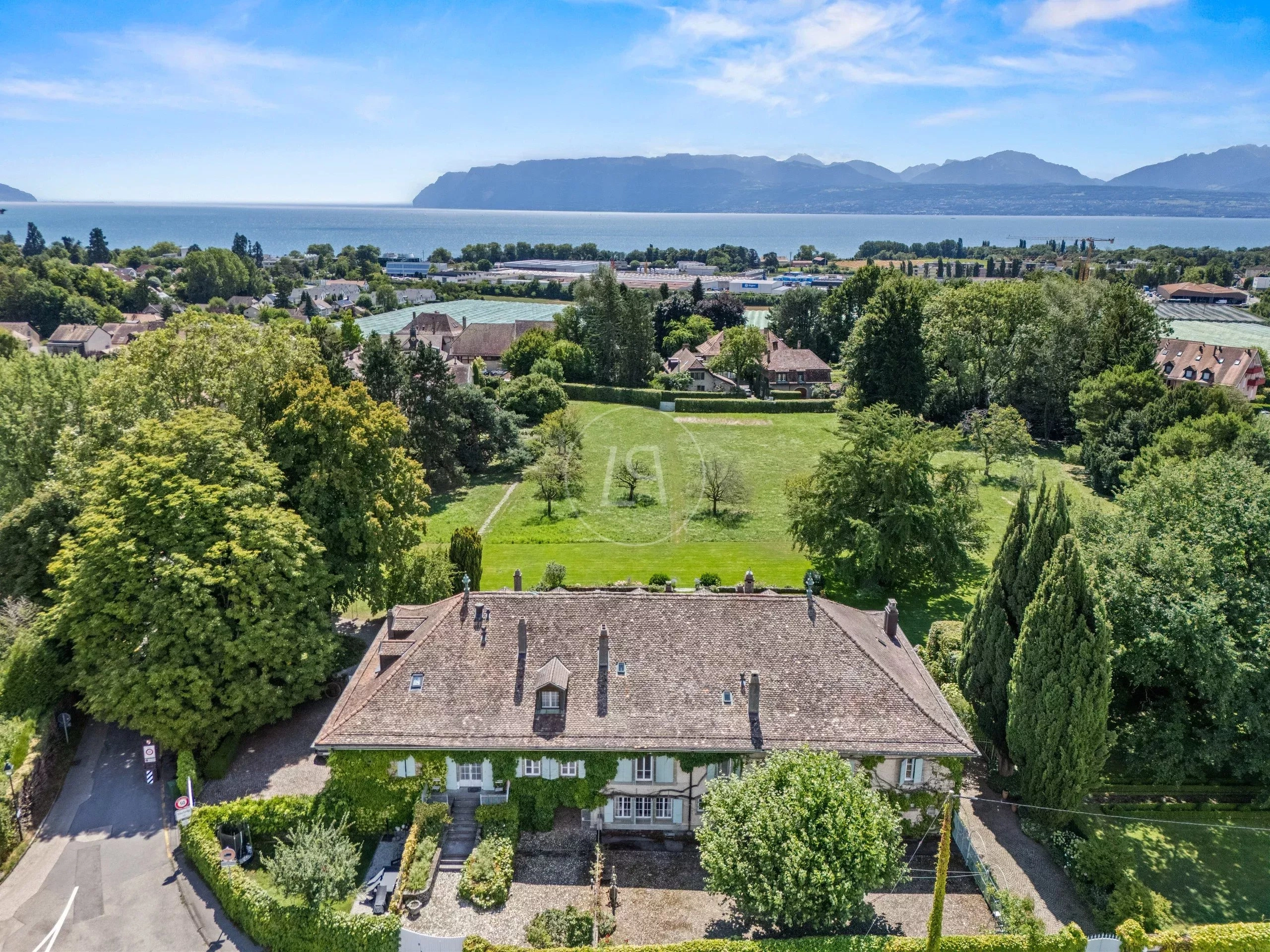 Luftaufnahme eines Hauses mit Seeblick und großzügigem Garten