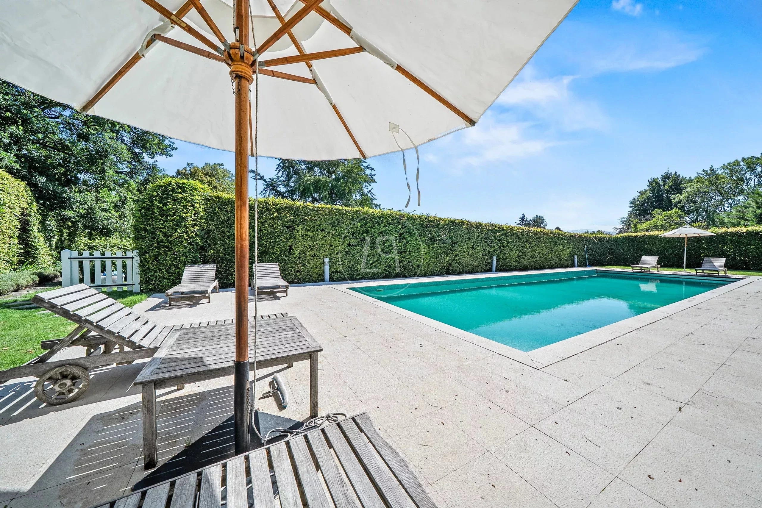 Außenbereich mit Pool und Sonnenliegen