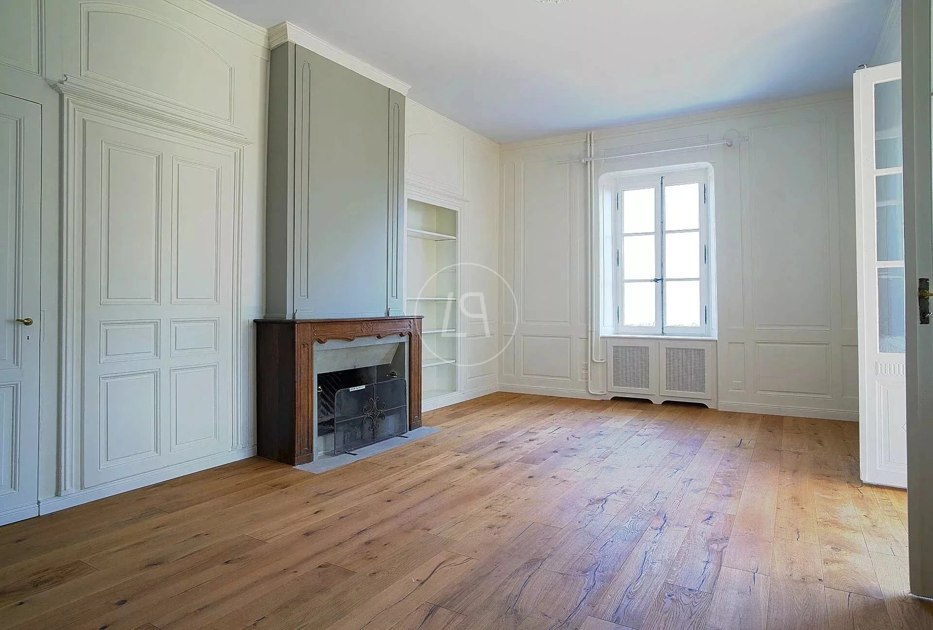 Heller Altbau-Raum mit Kamin und Holzboden