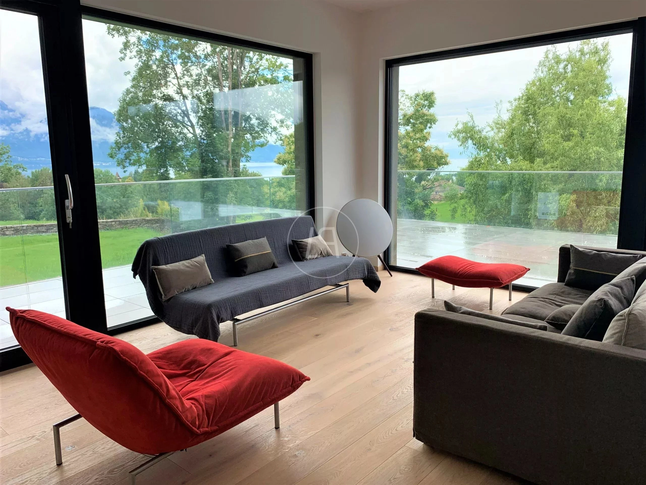 Moderner Wohnraum mit großer Glasfront und Bergblick
