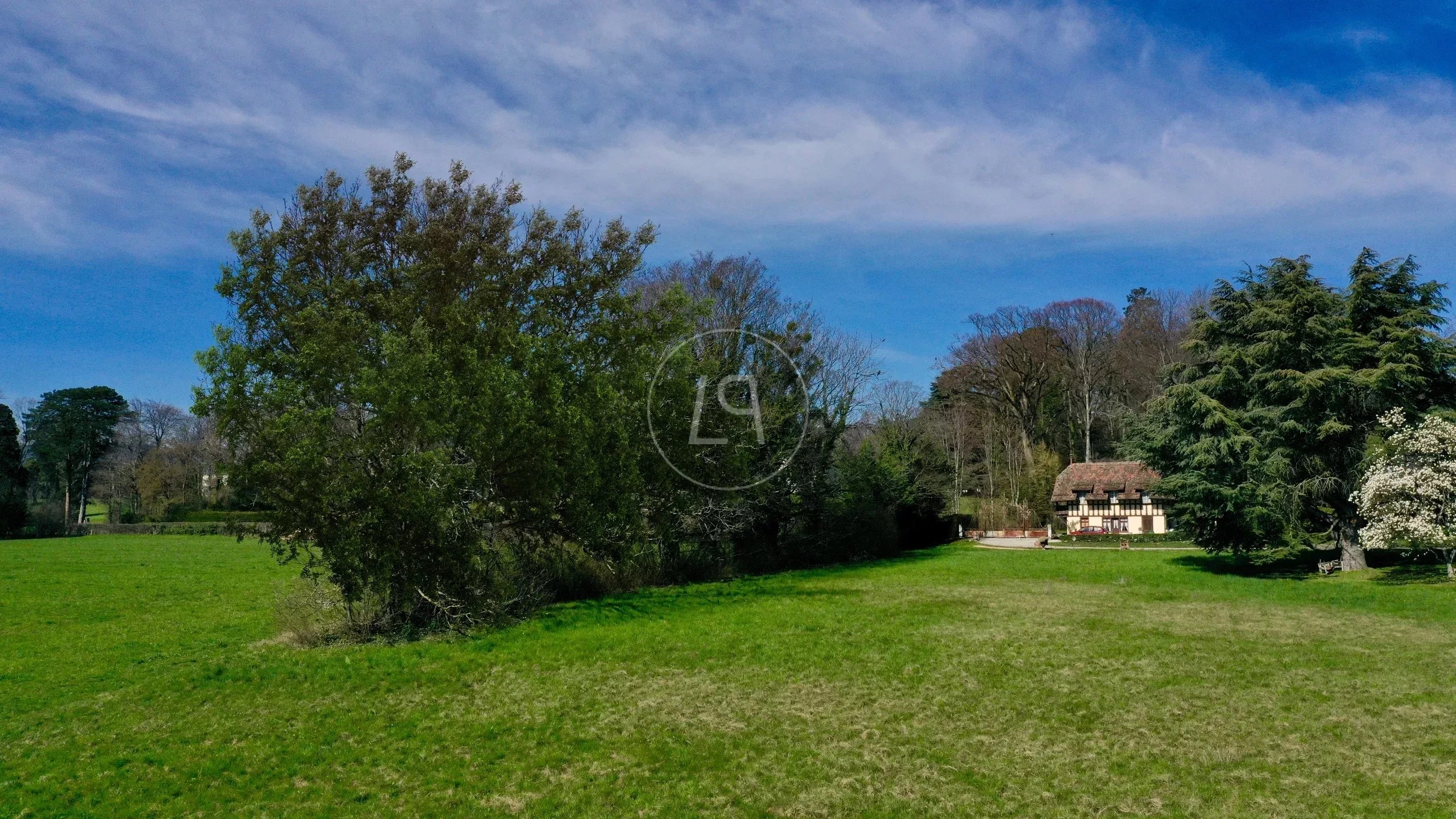 Weite Park- und Gartenlandschaft mit Haus im Hintergrund