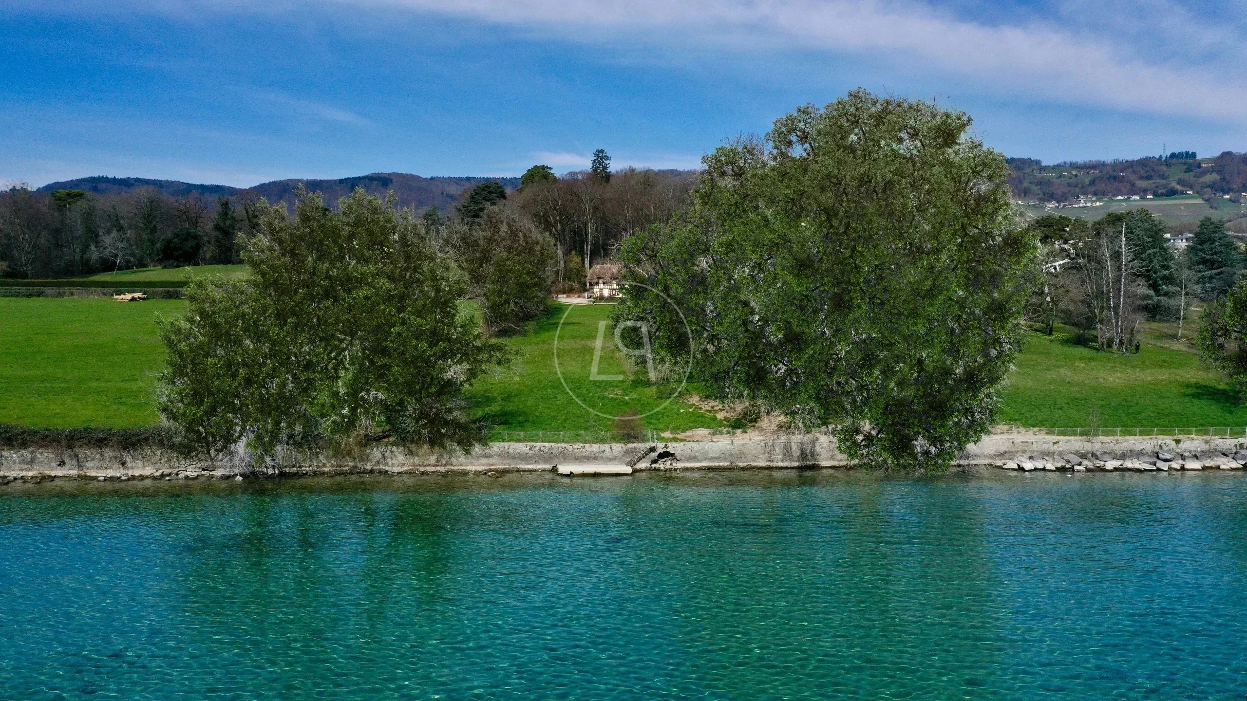 Ufergrundstück am See mit Wiese und Bäumen