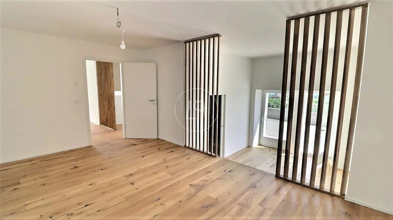 Helles Zimmer mit Holzfußboden und vertikalen Holzlamellen
