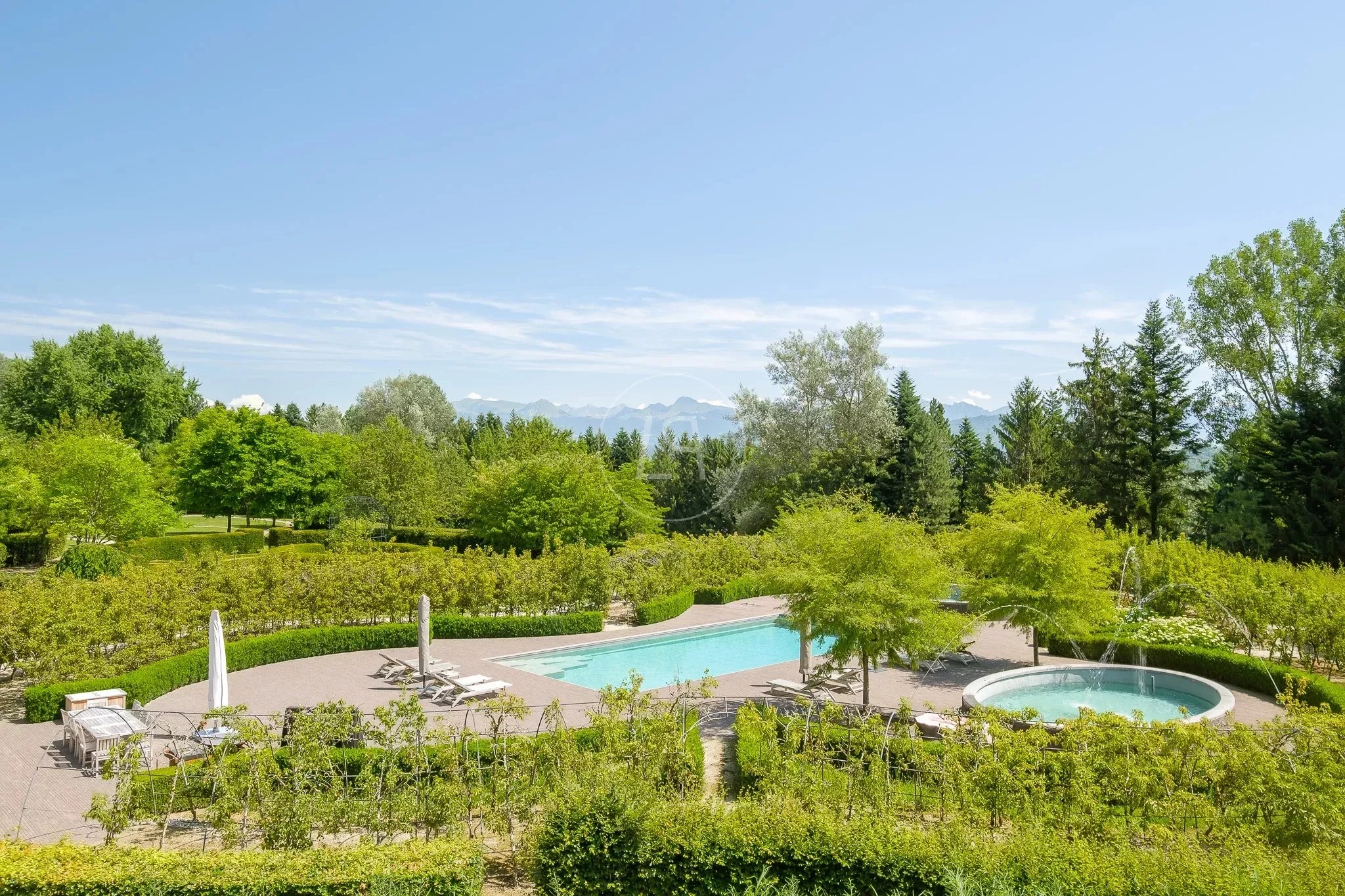 Außenansicht eines großzügigen Gartens mit Pool und Bergblick