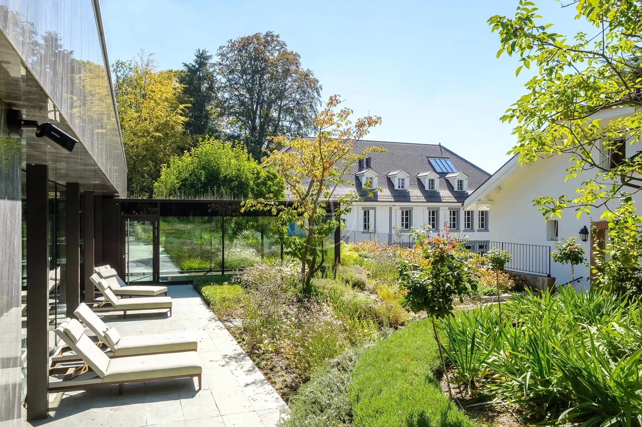 Moderner Garten mit Liegen und Glasüberdachung