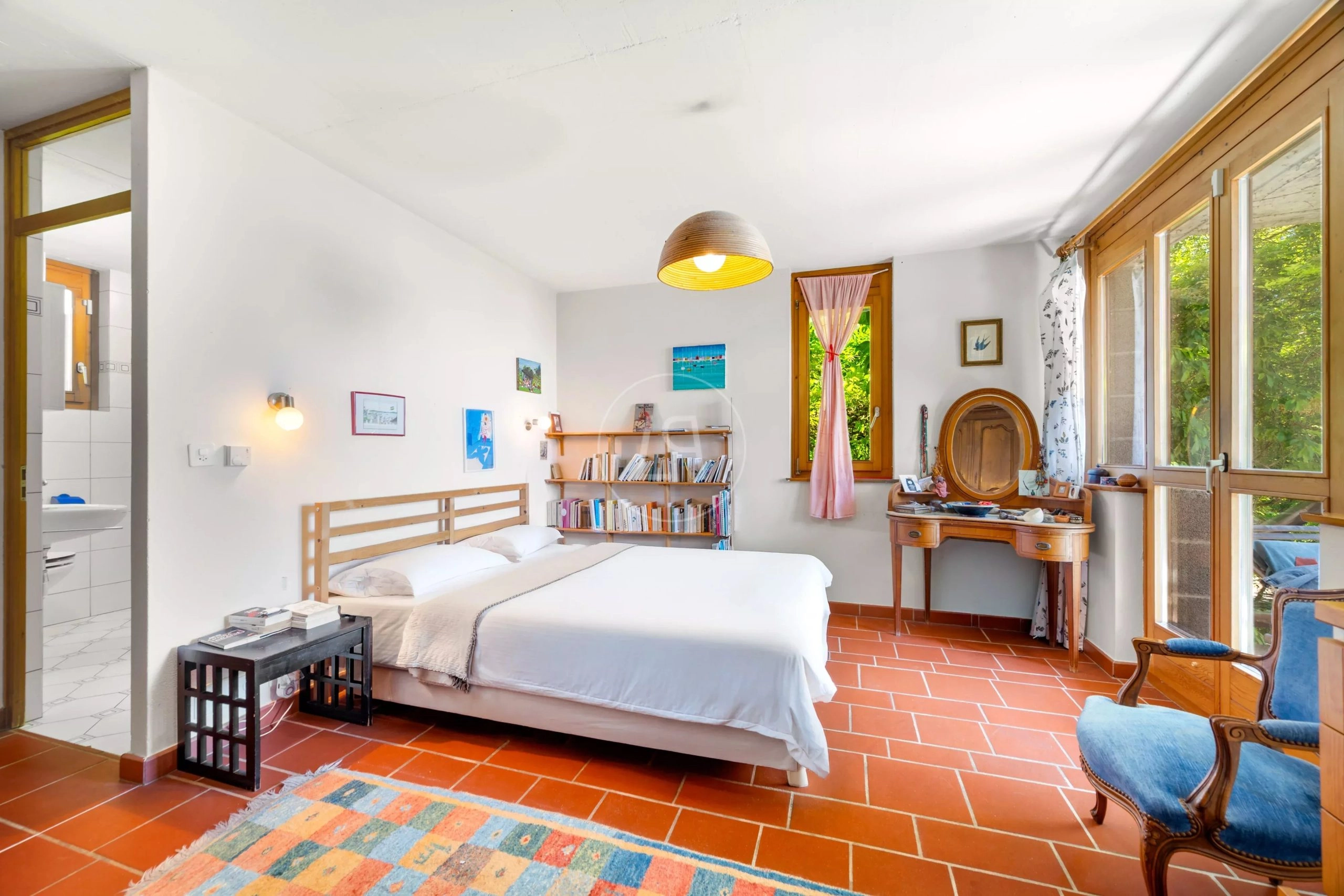 Helles Schlafzimmer mit Terrakottaboden und Gartenblick