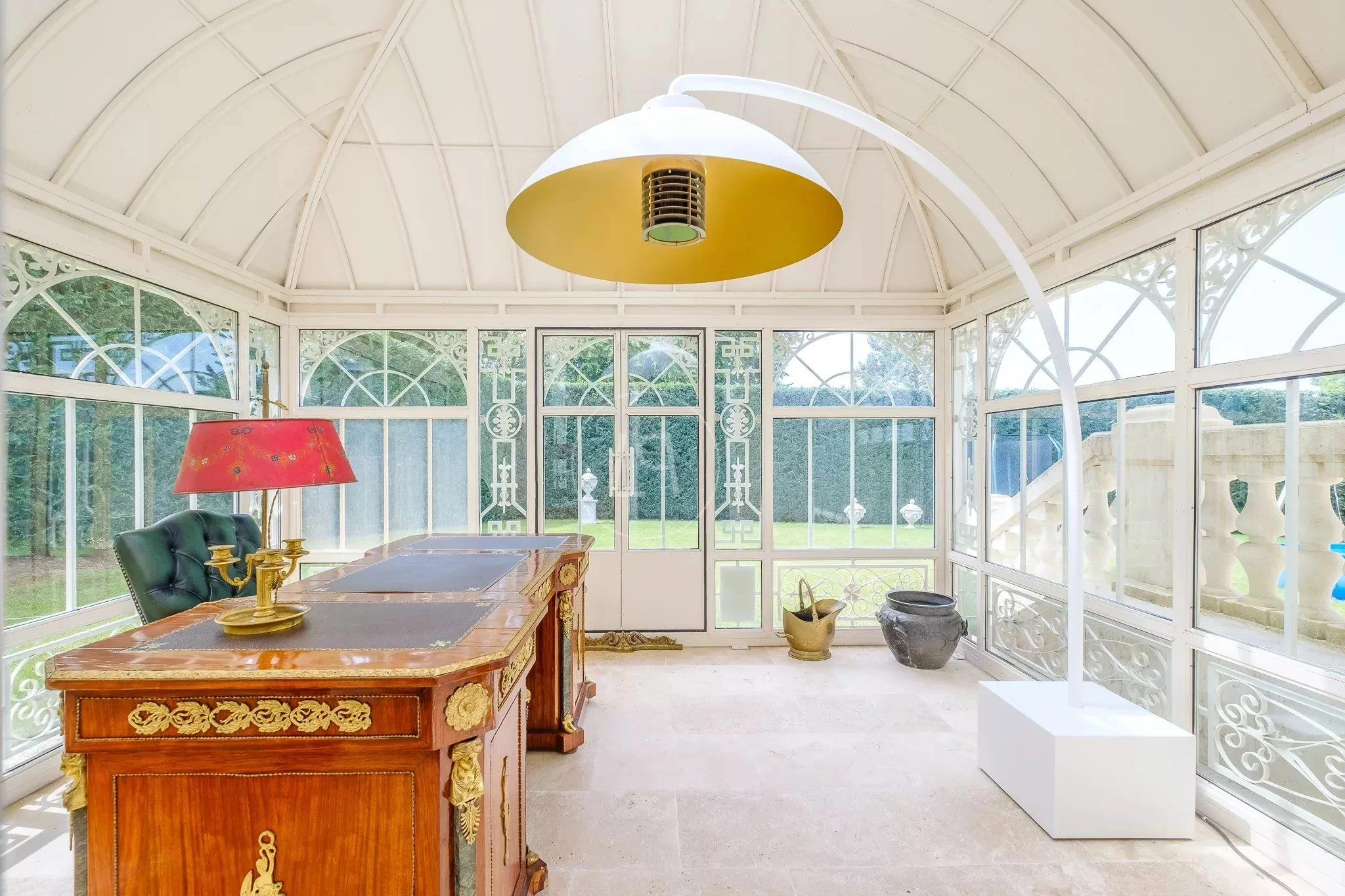 Eleganter Wintergarten mit Schreibtisch und Gartenblick