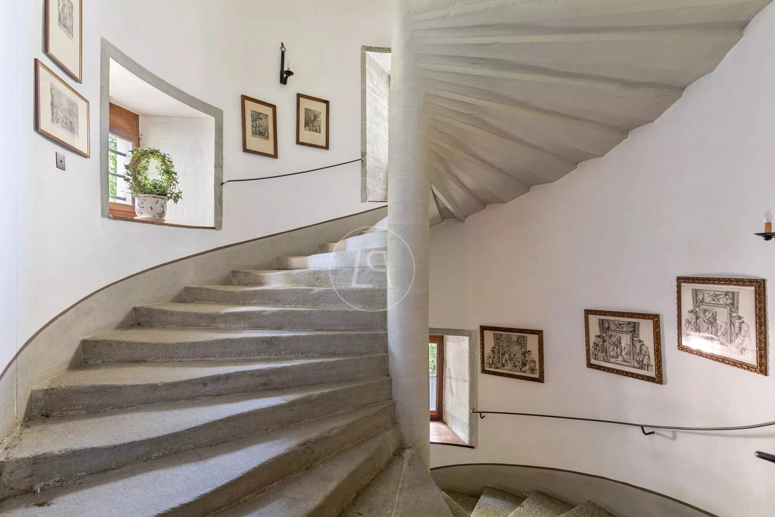 Gewundene Treppe mit Kunst und Fensteröffnung