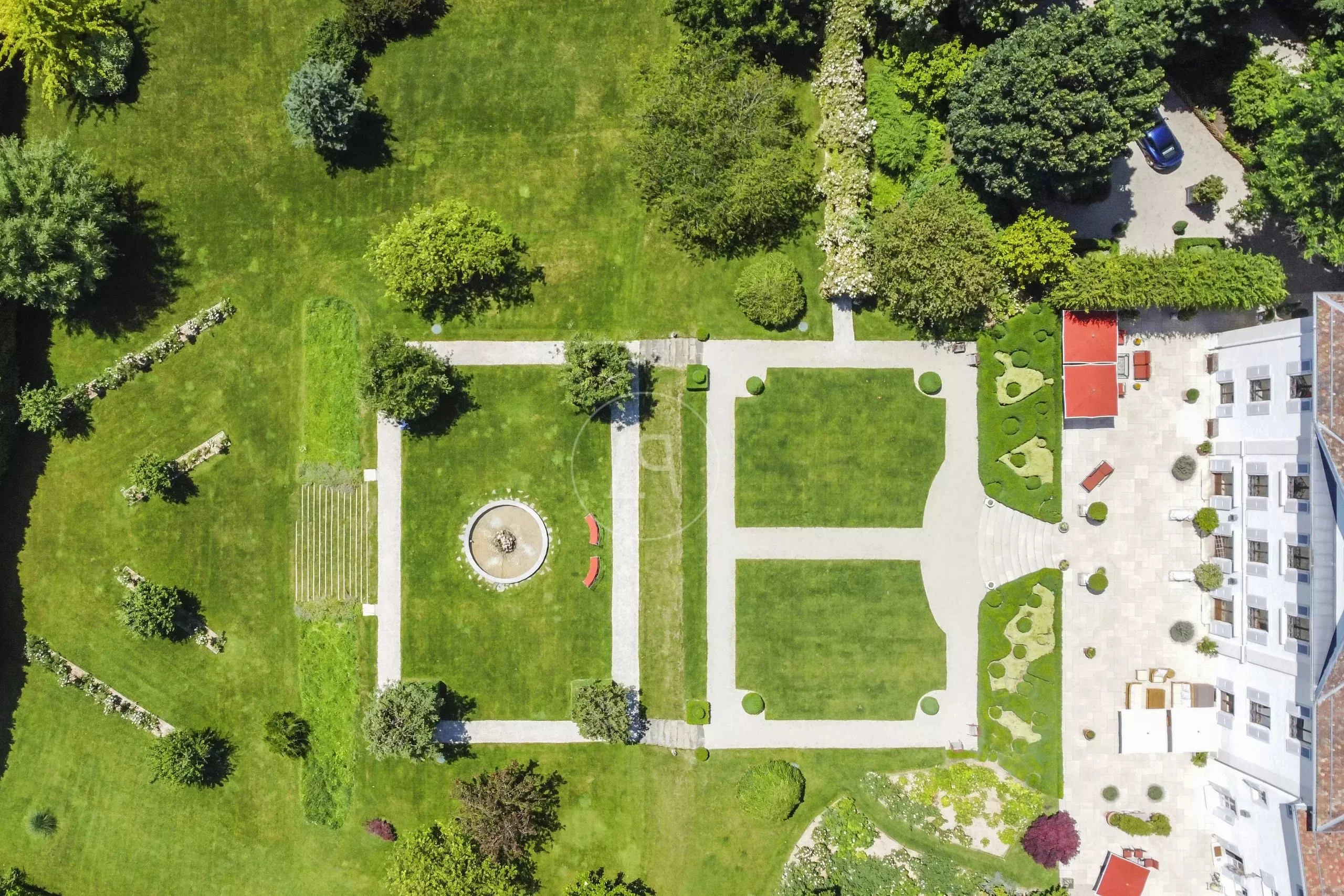 Luftaufnahme einer großen Garten- und Parkanlage mit Villa