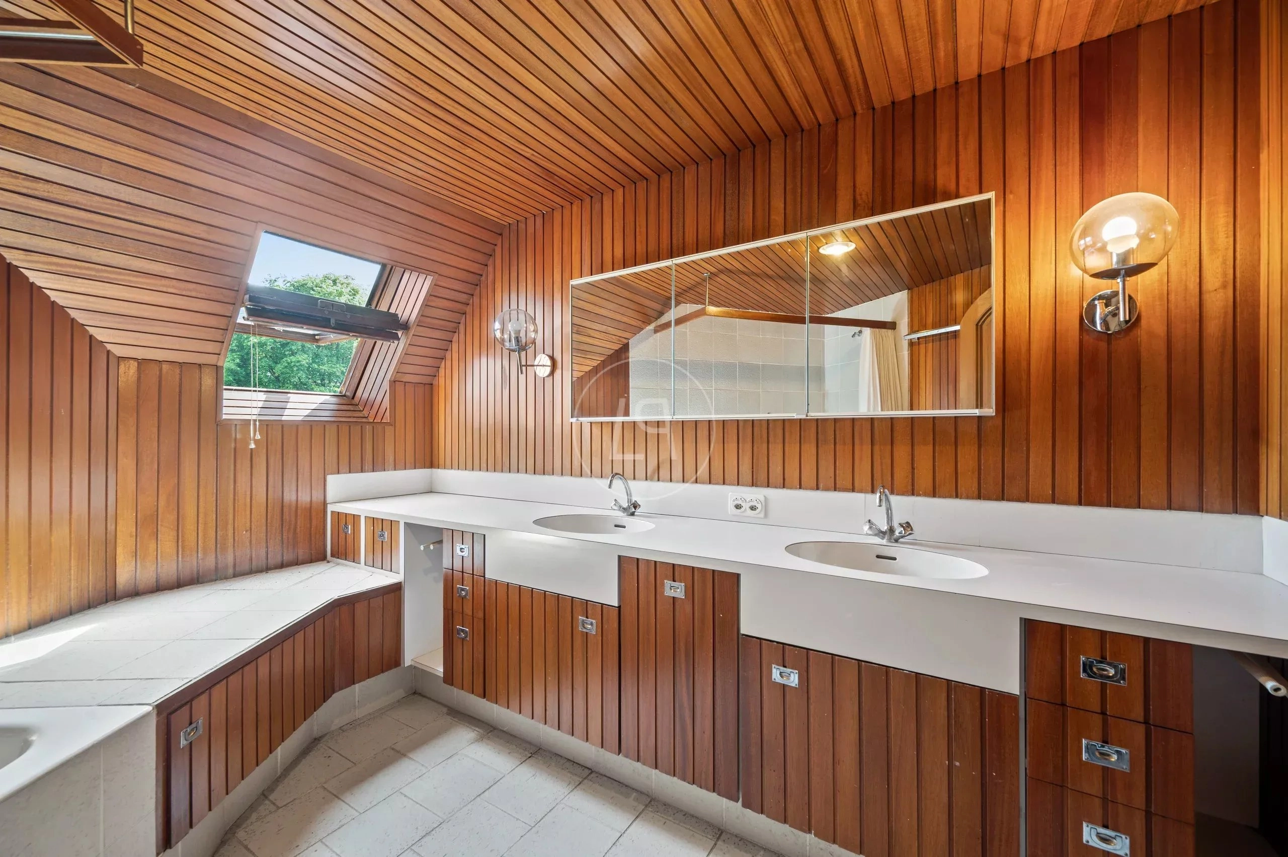 Badezimmer mit Holzverkleidung und Dachfenster